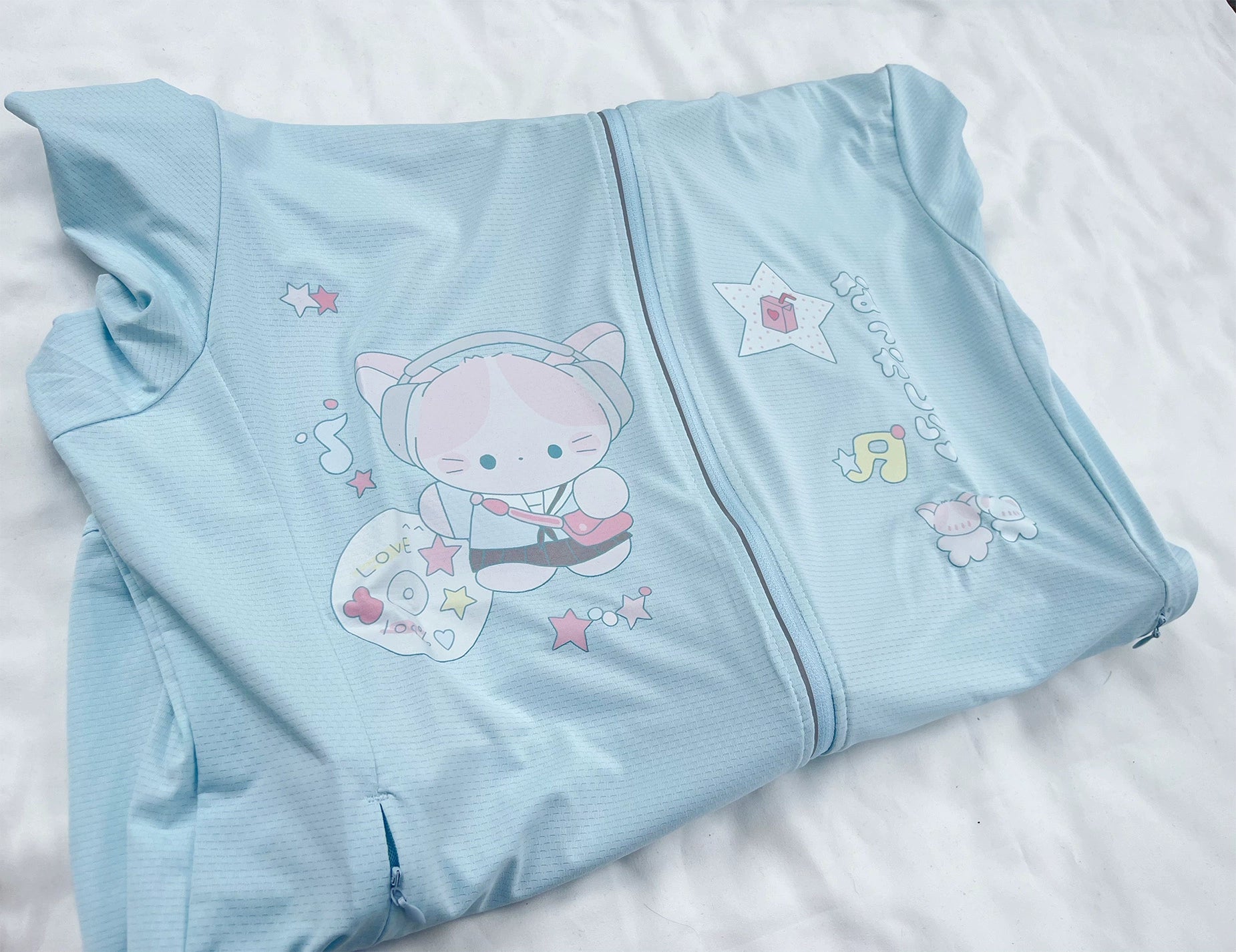 Jirai kei sun-protective jacket in water blue with UPF50 plus rating, showing cute cartoon prints and functional pocket details for outdoor summer wear