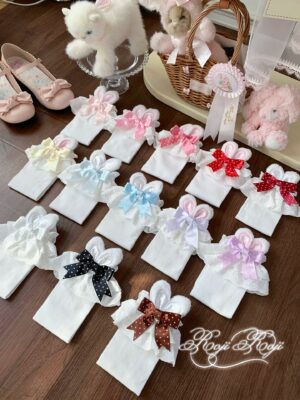 Assorted Jirai Kei mid-calf socks collection with white base and colored bunny ear trims displayed flat lay on wooden table with plush ornaments