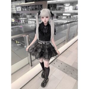 Jirai Kei black blouse plaid skirt tulle overlay ensemble front three-quarter view outdoor shopping mall model wearing complete outfit with layered skirt details