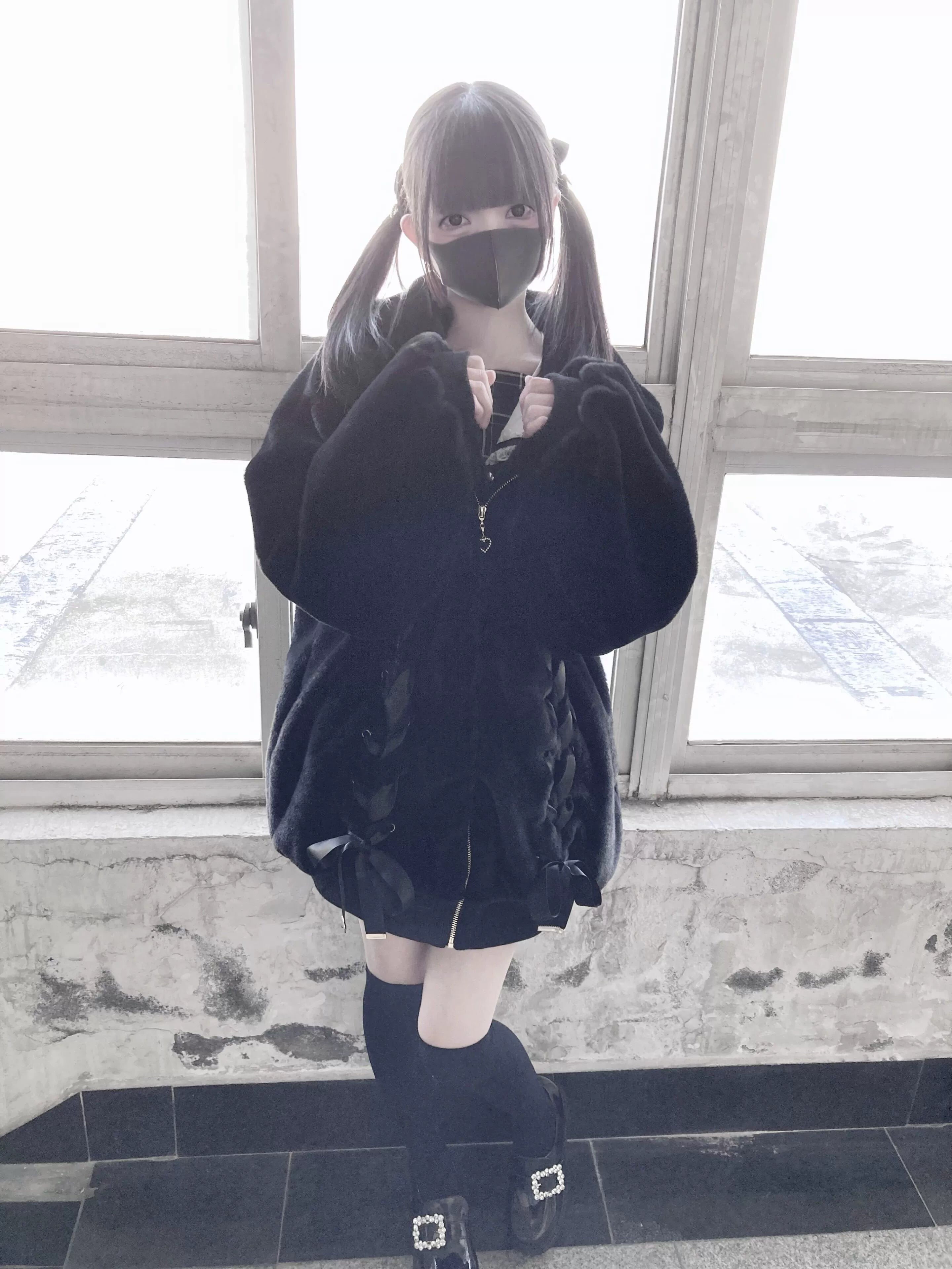 Twin-tail model wearing black plush fleece coat with decorative zipper and heart-shaped pull front medium view