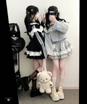 Jirai Kei hooded jacket and tiered ruffle skirt set modeled in mirror selfie showing side profile of two models wearing black and gray outfits with ruffled details and lace trim