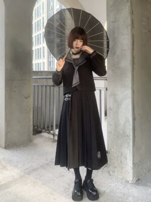 Black gothic sailor JK uniform set with long pleated skirt, grey sailor tie, embroidered chest crest, and oiled paper umbrella styled on model outdoors