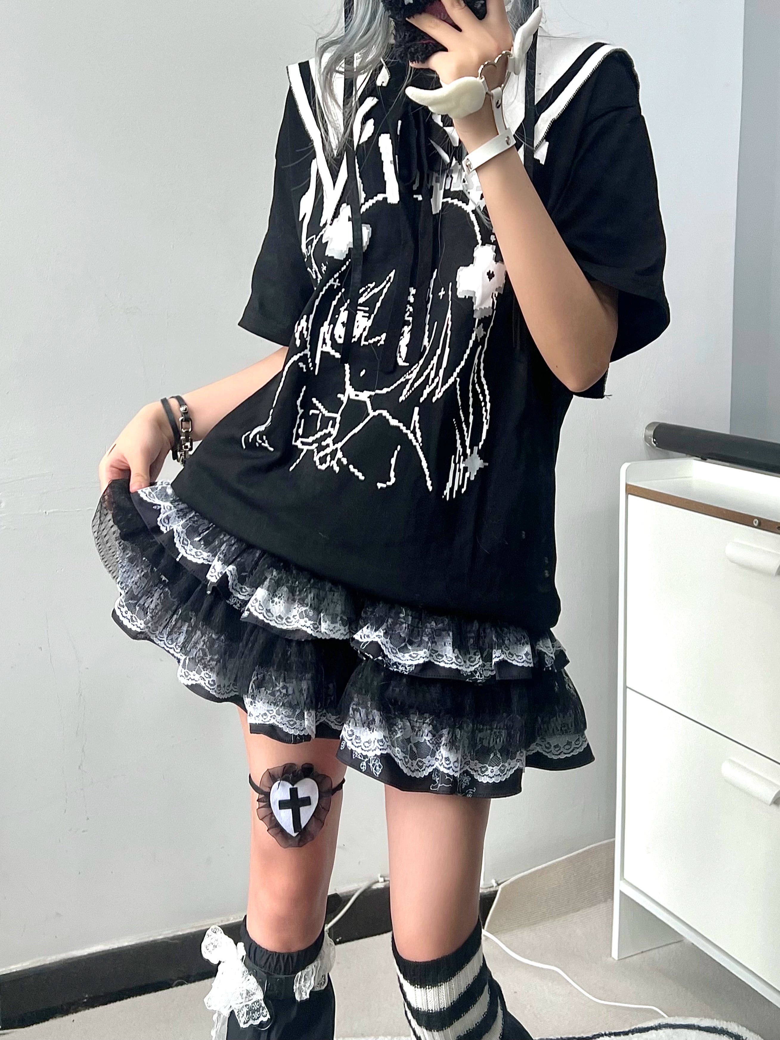 Close-up low angle shot of tiered black lace puff skirt with cross thigh sticker and striped socks detail Jirai Kei styling