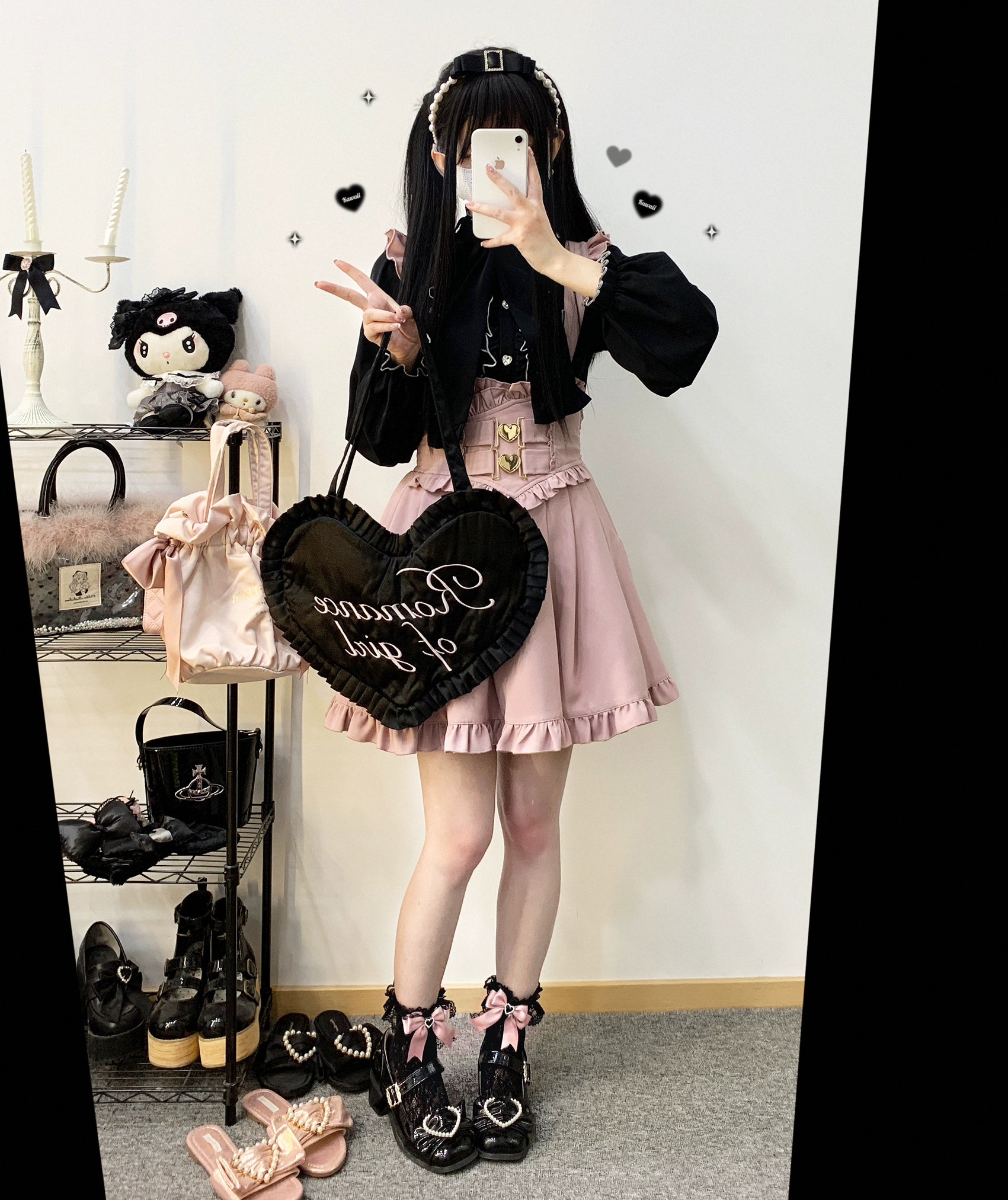 Full-body Jirai Kei outfit featuring pink ruffled suspender skirt with black ruffled blouse black heart-shaped handbag and bow ankle boots
