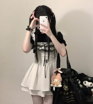 White Jirai Kei chiffon blouse with delicate lace bust trim and heart-shaped buttons, paired with suspender mini skirt, full front mirror selfie with pink hair accessories