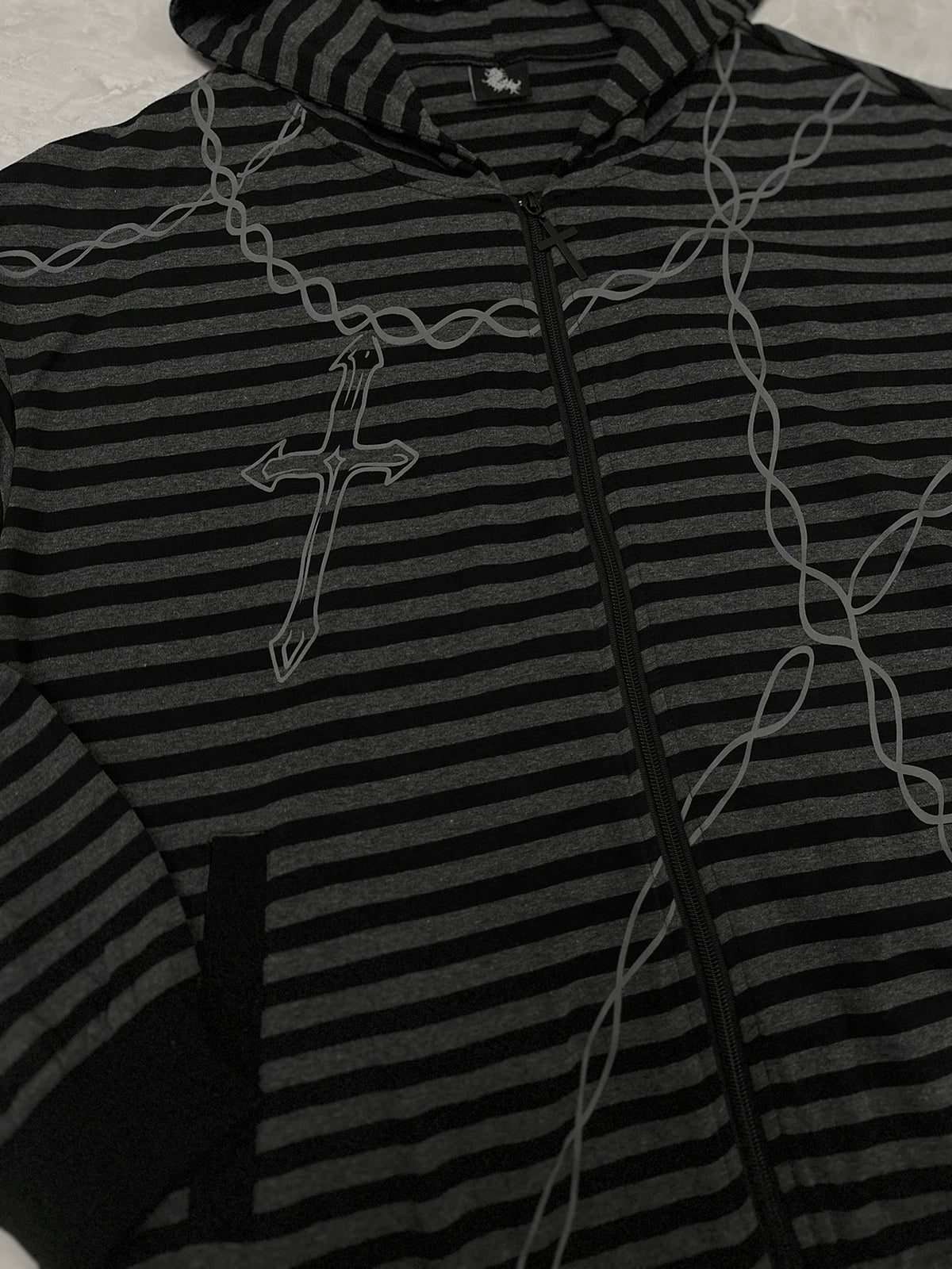 Gothic striped hoodie outdoor back view worn by female model with blue-streaked hair on street, featuring striped pattern and back gothic letter print