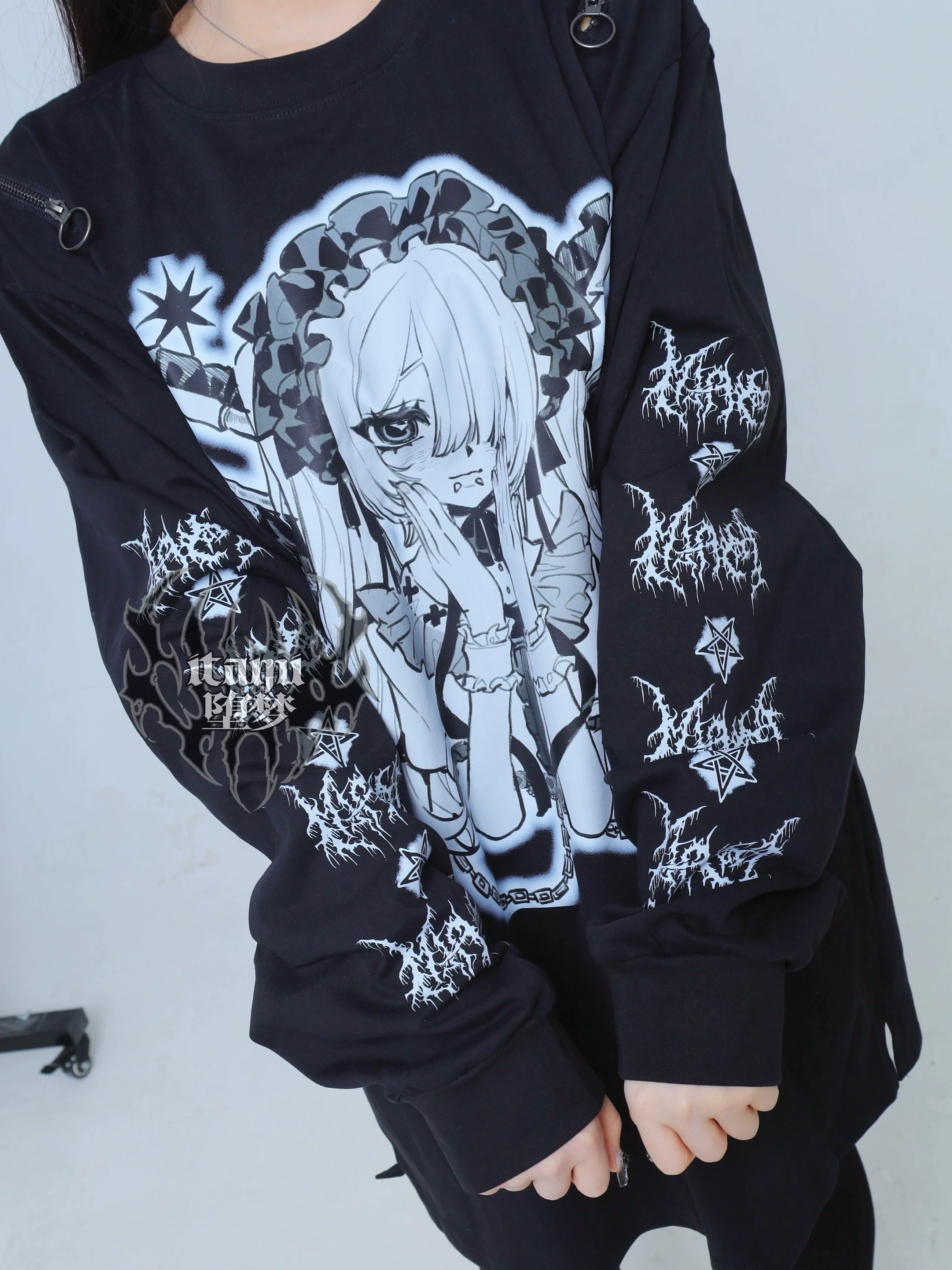 Flat lay detail shot black gothic anime long-sleeve tee grayscale print thorn sleeve prints shoulder metal ring accents
