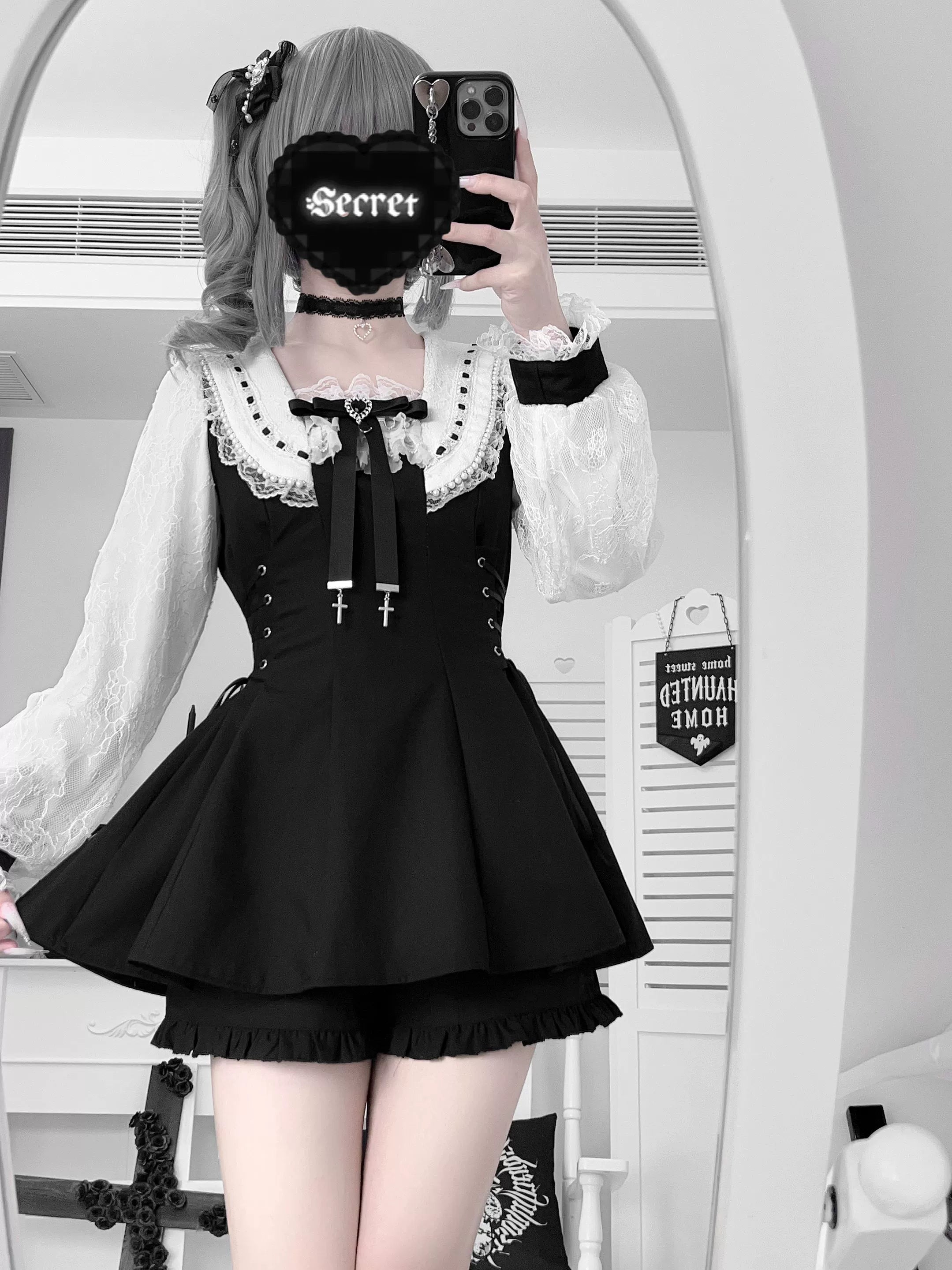 Mirror selfie upper-thigh shot of model wearing solid black Jirai Kei set with heart-themed phone cover and twin ponytails