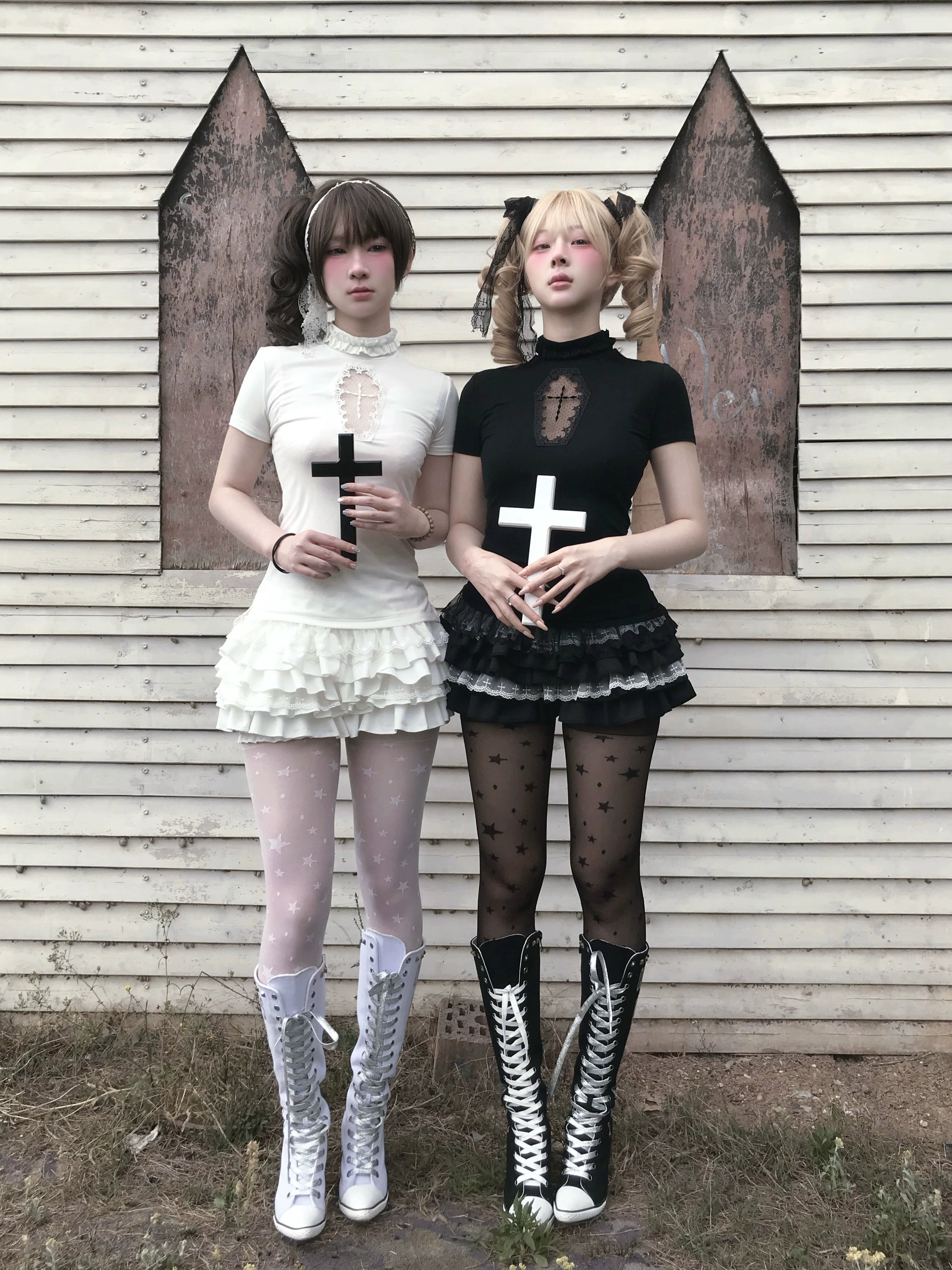 Dual gothic Jirai Kei ensemble showcase with cross props full body view grass background