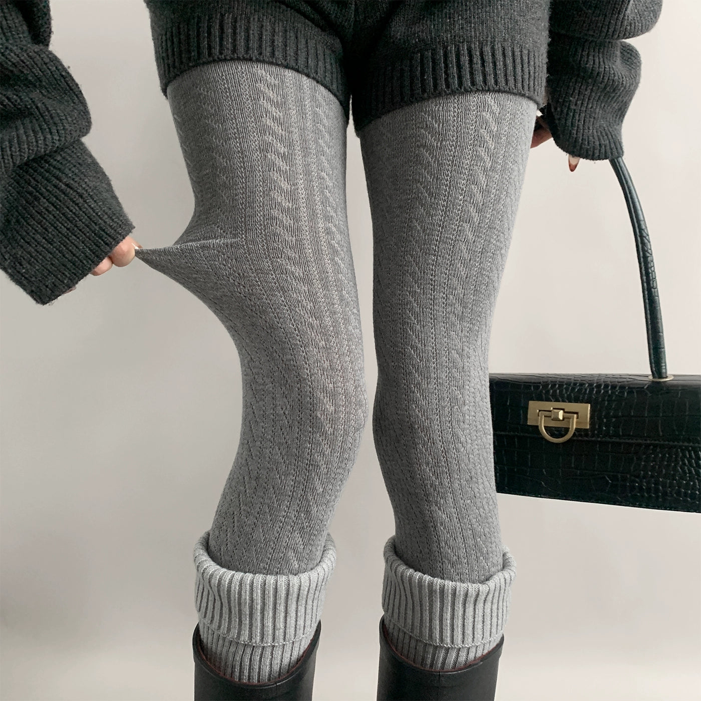 Gray Jirai Kei hollow vertical stripe knit tights front close-up showing twisted texture detail with studio lighting