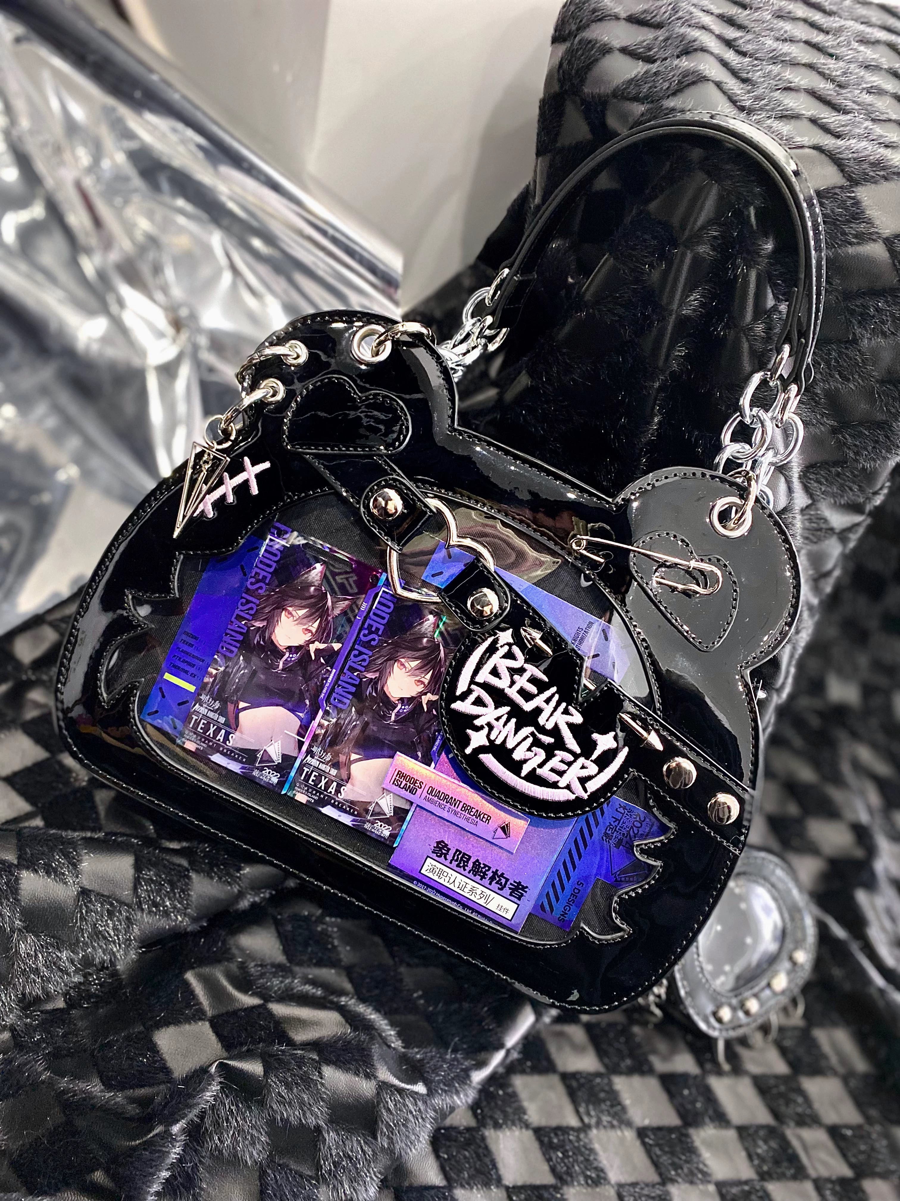 Black patent leather bear ita bag with built-in anime badge display window, chain strap, and punk metal accessories, top view