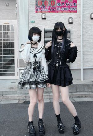 Two masked female models wearing Jirai Kei sailor collar blouses with matching gingham check skirts and platform loafers outdoors, showcasing complete street fashion ensemble with sailor collar details and complementary accessories