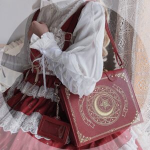 Wine red magic book Jirai Kei crossbody bag with golden tarot celestial print, worn by model in elegant Lolita ruffled dress with lace curtain backdrop, side back overhead view