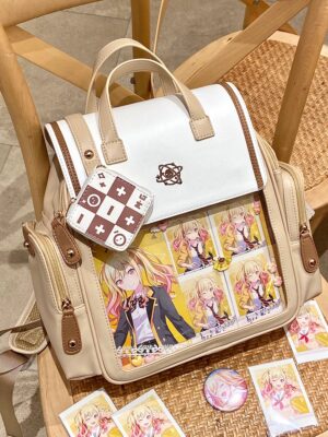 Jirai Kei itabag backpack three-quarter front view with transparent display window showcasing anime badges and character cards on wooden table with kawaii accessories
