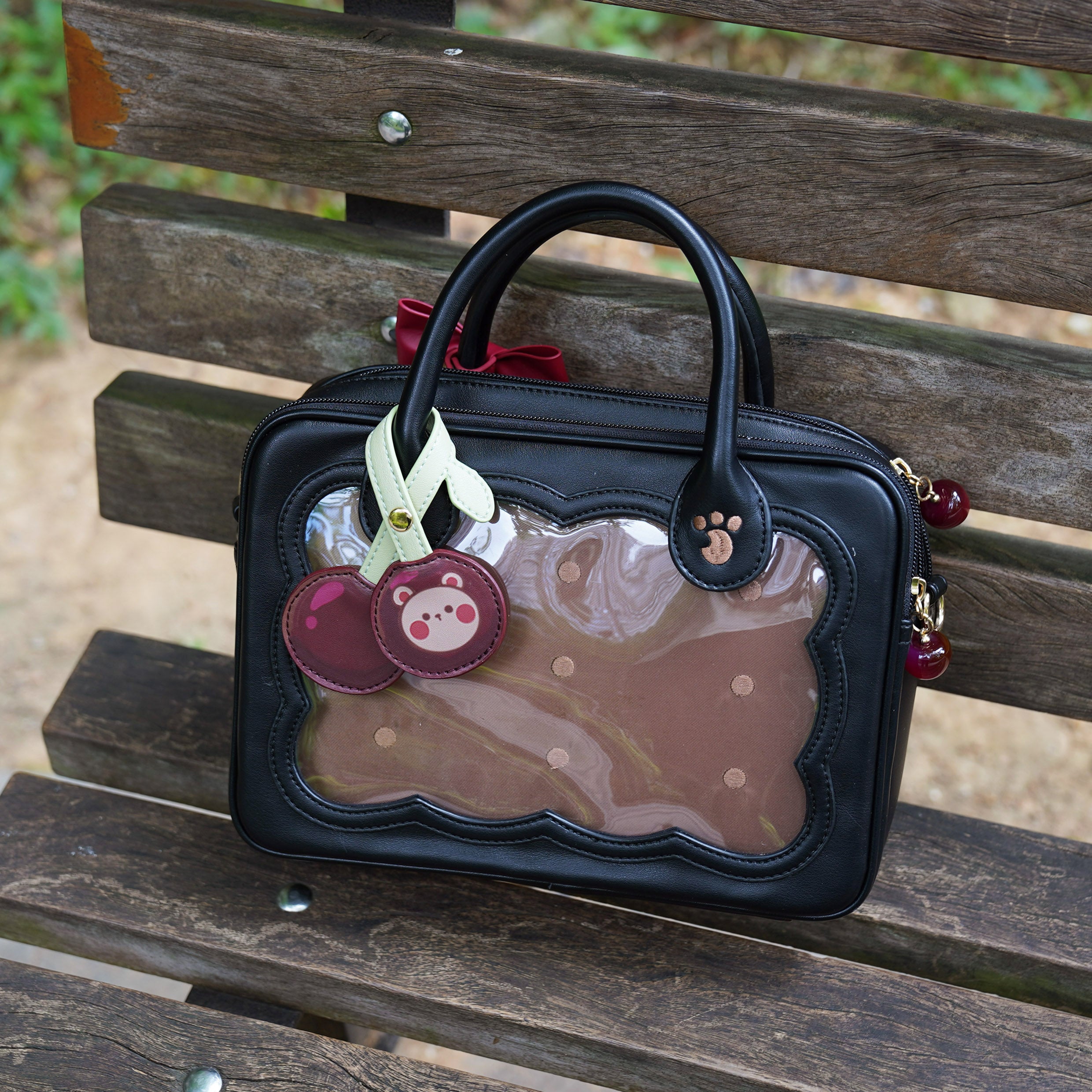 Matte black cherry bear cookie Jirai Kei crossbody bag with hidden red bow and cherry embroidery detail flat lay