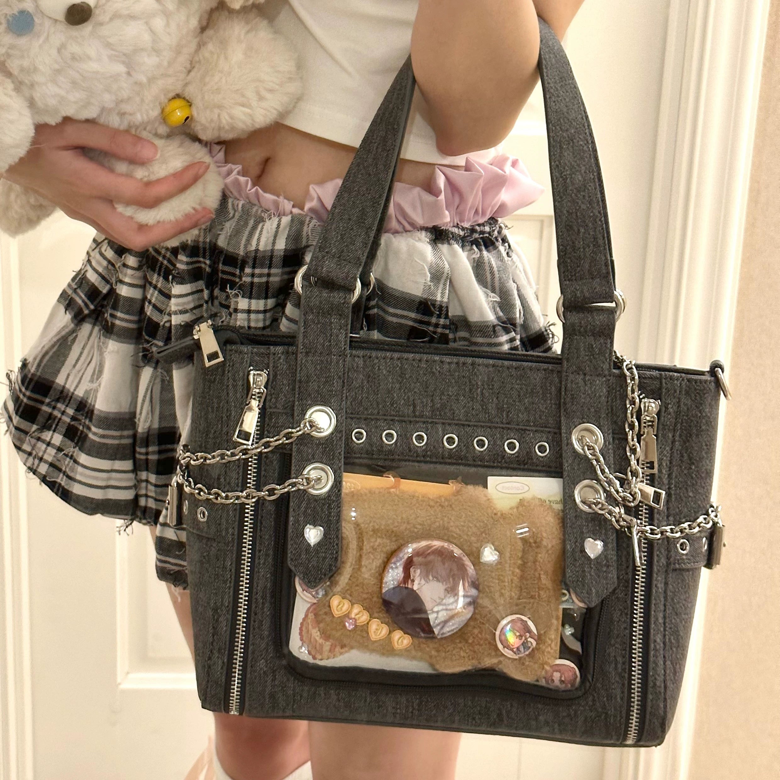 Dark grey denim Jirai Kei ita bag worn by girl in plaid skirt holding plush toy with bear-themed display inside