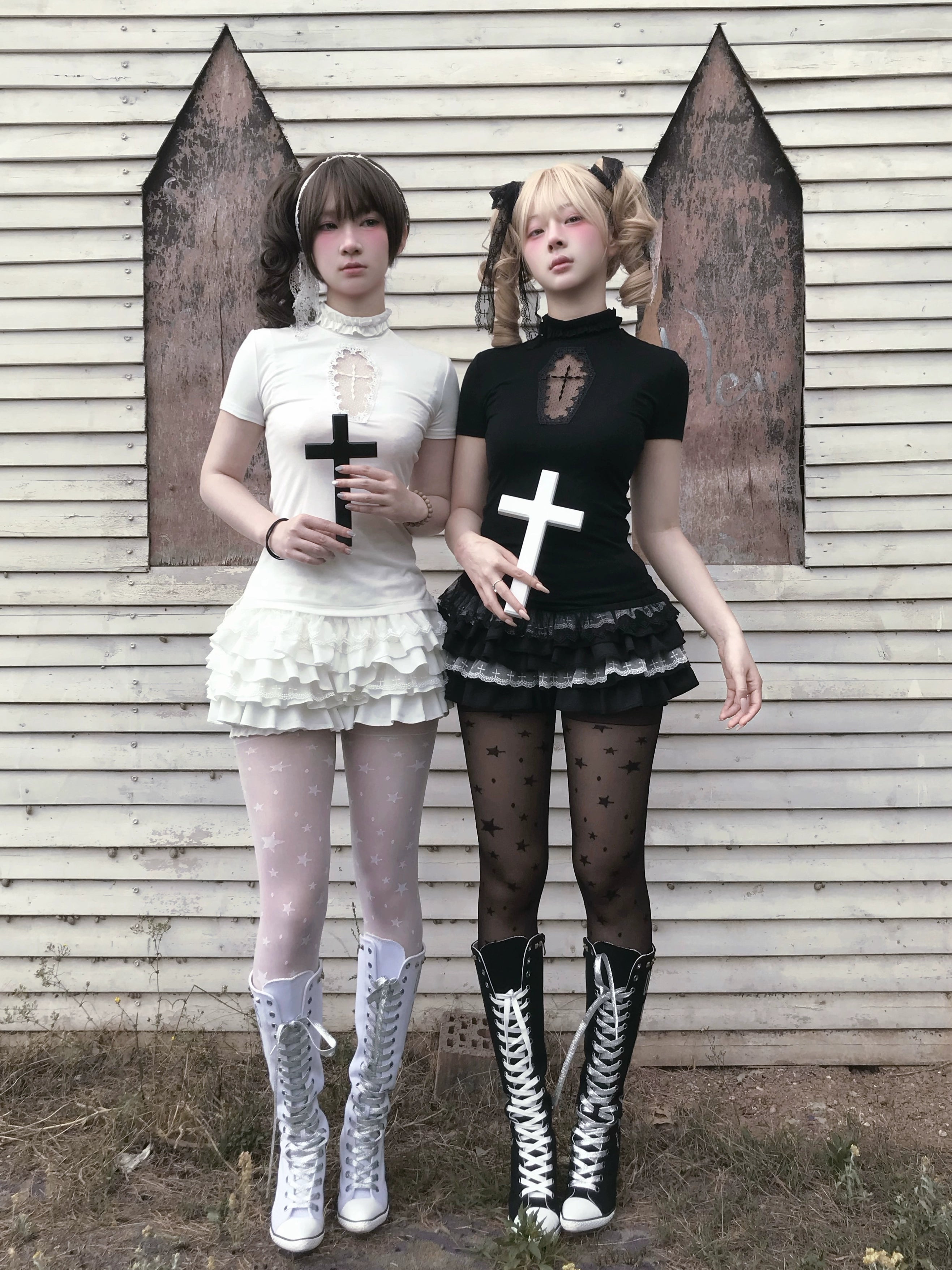 Full body gothic Jirai Kei outfit styled with combat boots star-patterned tights and cross props