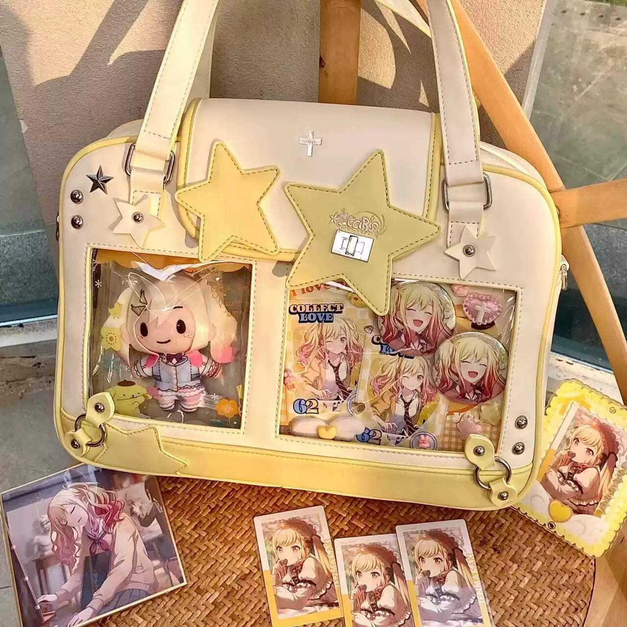 Yellow white star-themed Jirai Kei itabag three-quarter view with anime merchandise cross emblem