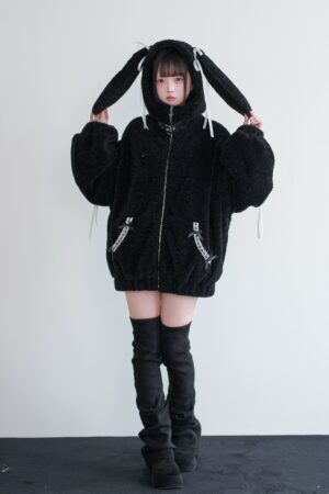 Black fuzzy bunny ear jirai kei winter coat front view with white ribbon hood details and full zipper closure on young female model
