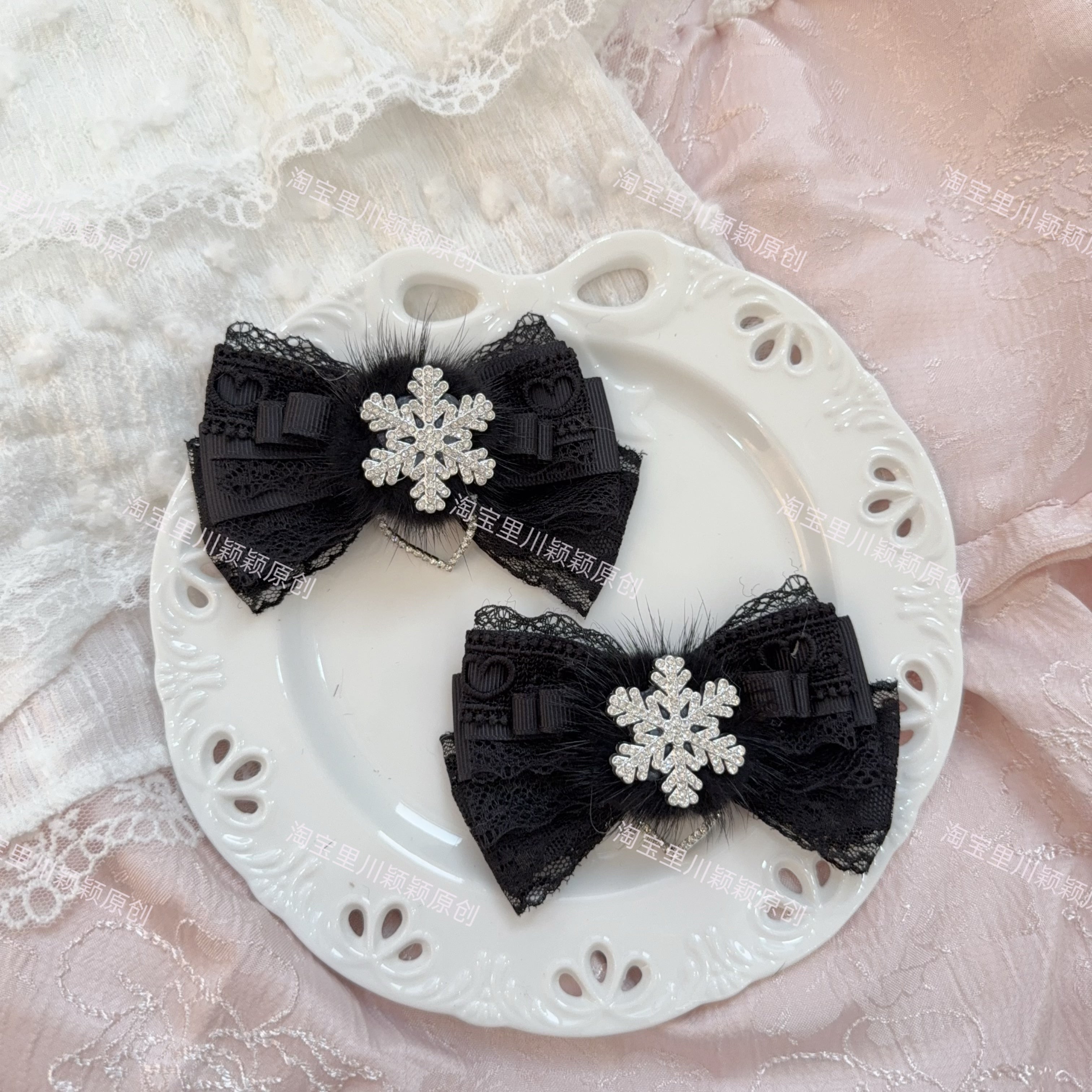 Pure black Jirai Kei bow hair clips with intricate lace heart cut-outs solid silver snowflake embellishment and heart pendant on white plate