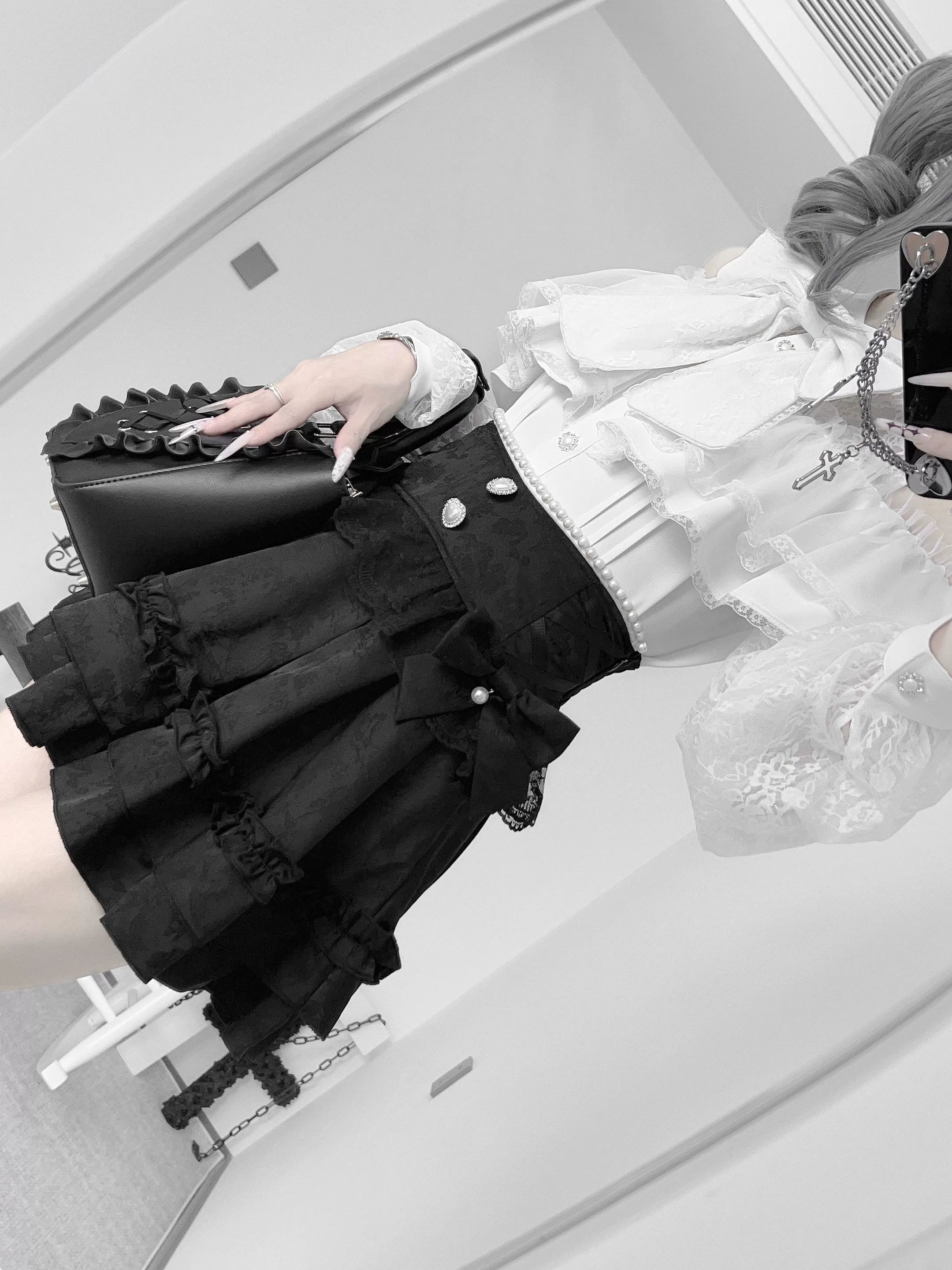 Black houndstooth jirai kei ruffle skirt with detachable bow element highlighted, product feature showcase and styling versatility
