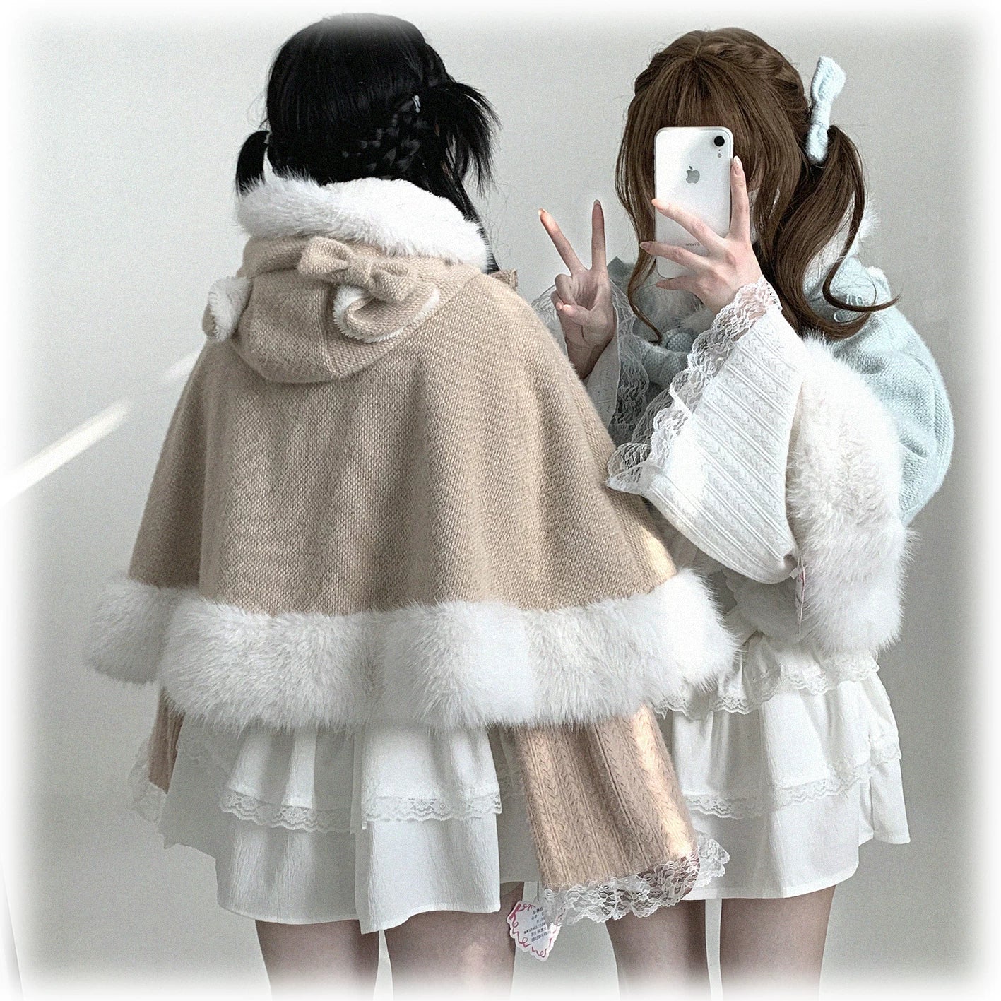 Overhead flat lay of cat-ear hooded cape showing full garment structure, detachable bow placement, and premium polar fleece material quality