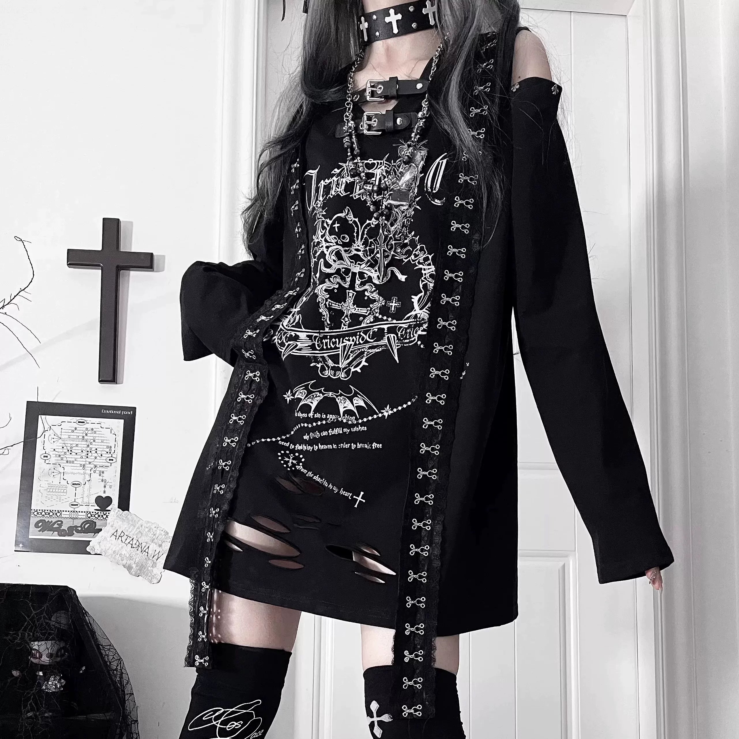 Full-front view of black goth long-sleeve T-shirt featuring distressed hemline and cut-out shoulders with detailed dark subculture graphics, worn by alternative model for Jirai Kei aesthetic