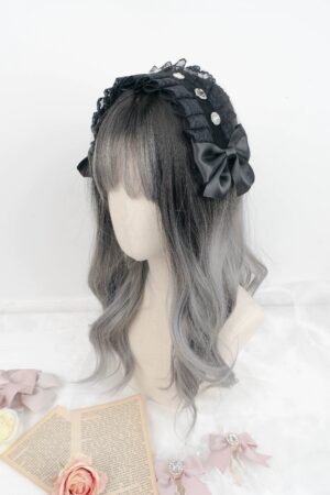 Black lace Jirai Kei headband with rhinestone studs and satin butterfly bow, front three-quarter view on mannequin head with gradient wig