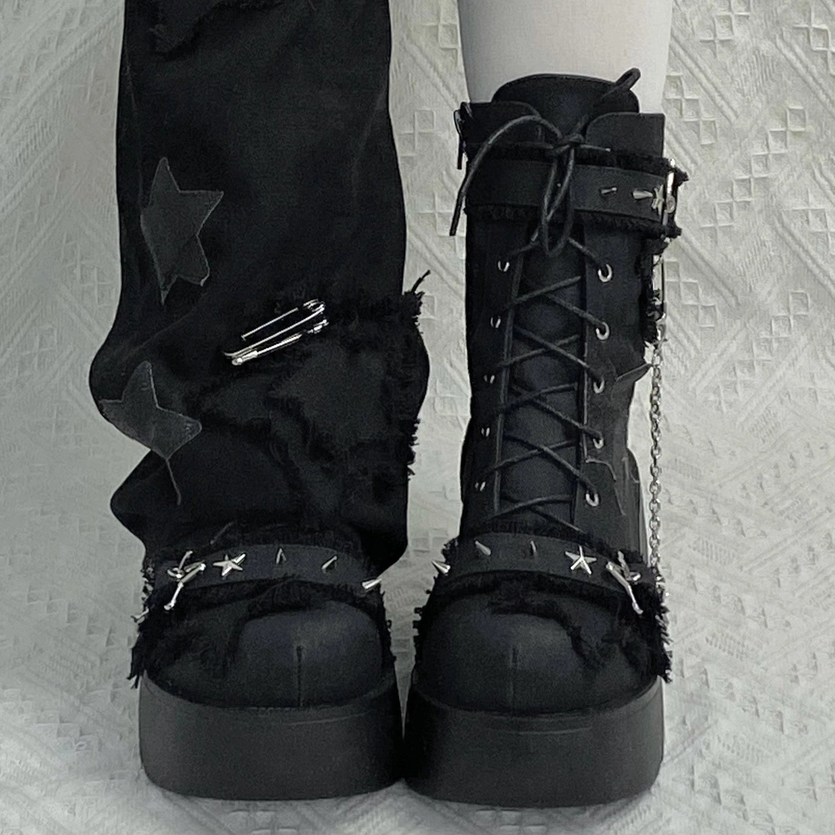 Y2K platform combat boots detail close-up showing 3D fringe star fabric metal rivets and chain embellishment craftsmanship