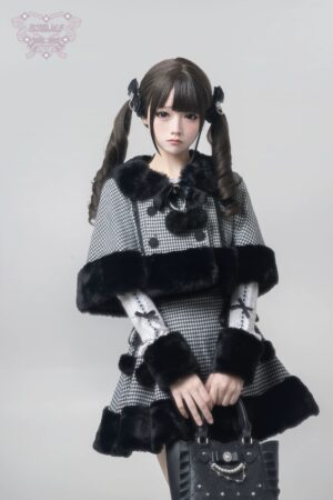 Houndstooth Jirai Kei cape and high-waisted skirt set frontal view, black and white houndstooth pattern with black faux fur trim, removable bow collar detail, modeled with twin ponytail hairstyle