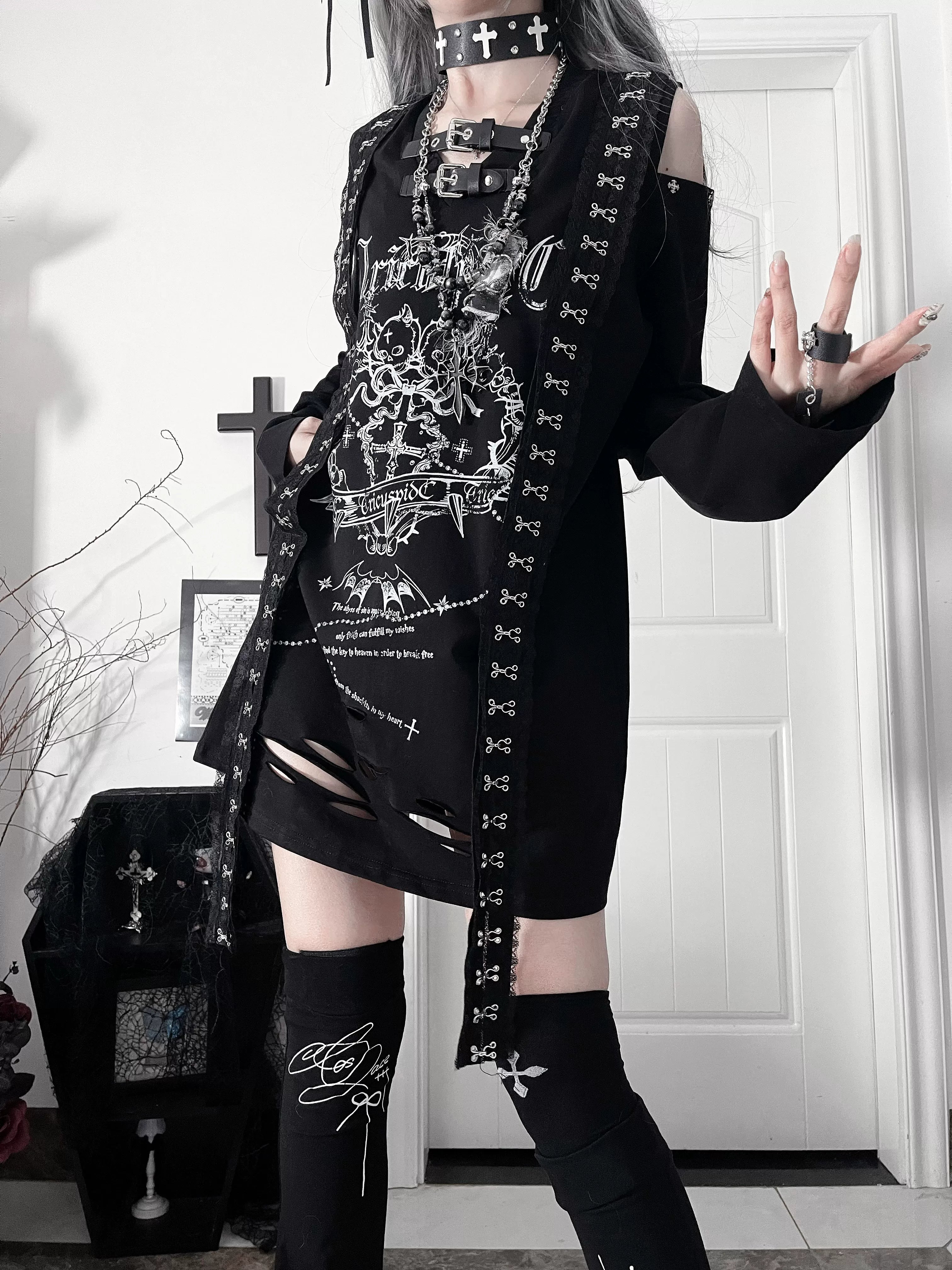 Black gothic long-sleeve Jirai Kei tee with white rebellious chest print and distressed hemline, featuring belted neck collar and cut-out shoulders for dark subculture aesthetic