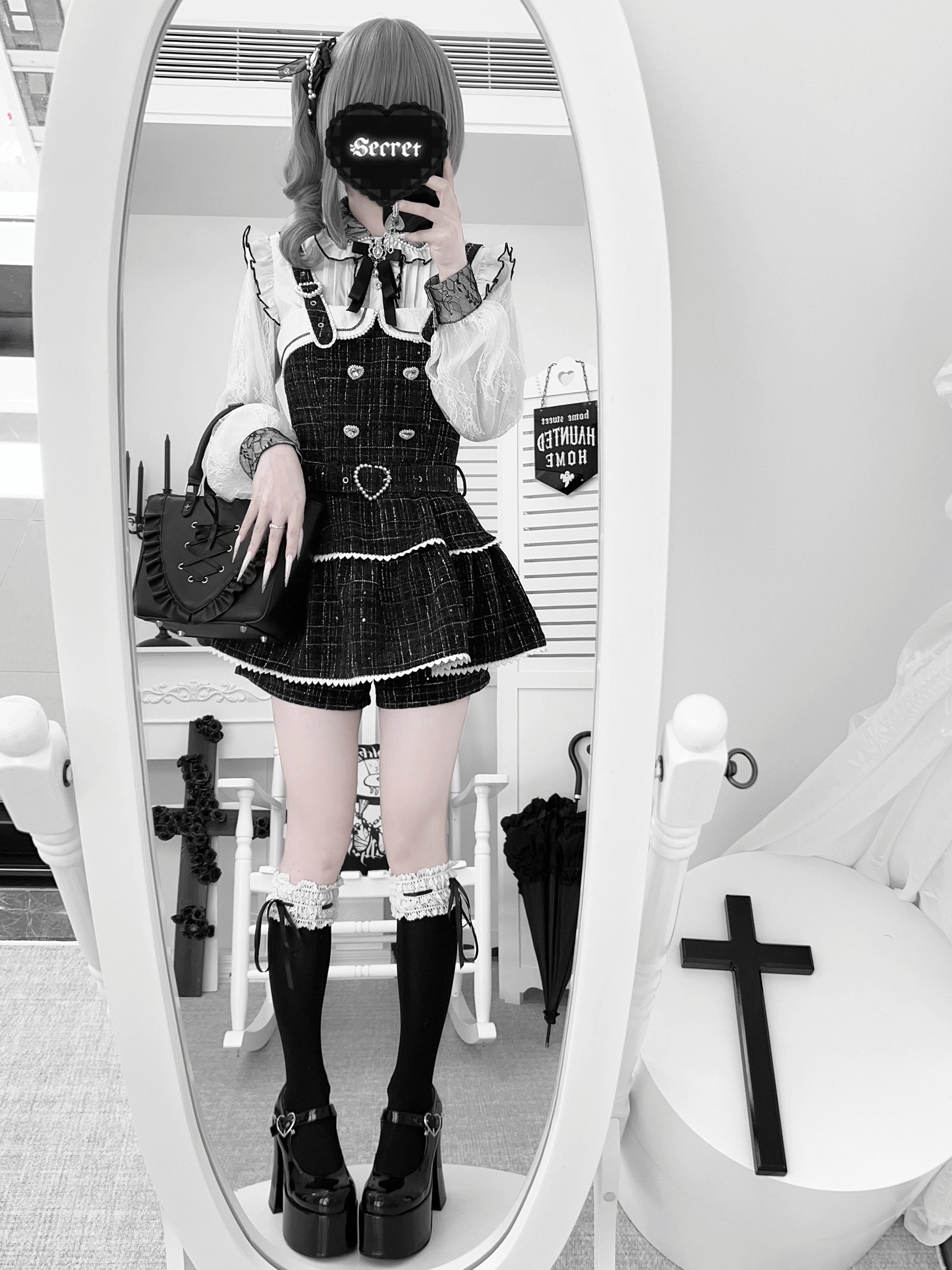 Black Jirai Kei suspender skirt with heart-shaped waist buckle and tiered ruffles, side mirror selfie view gothic aesthetic