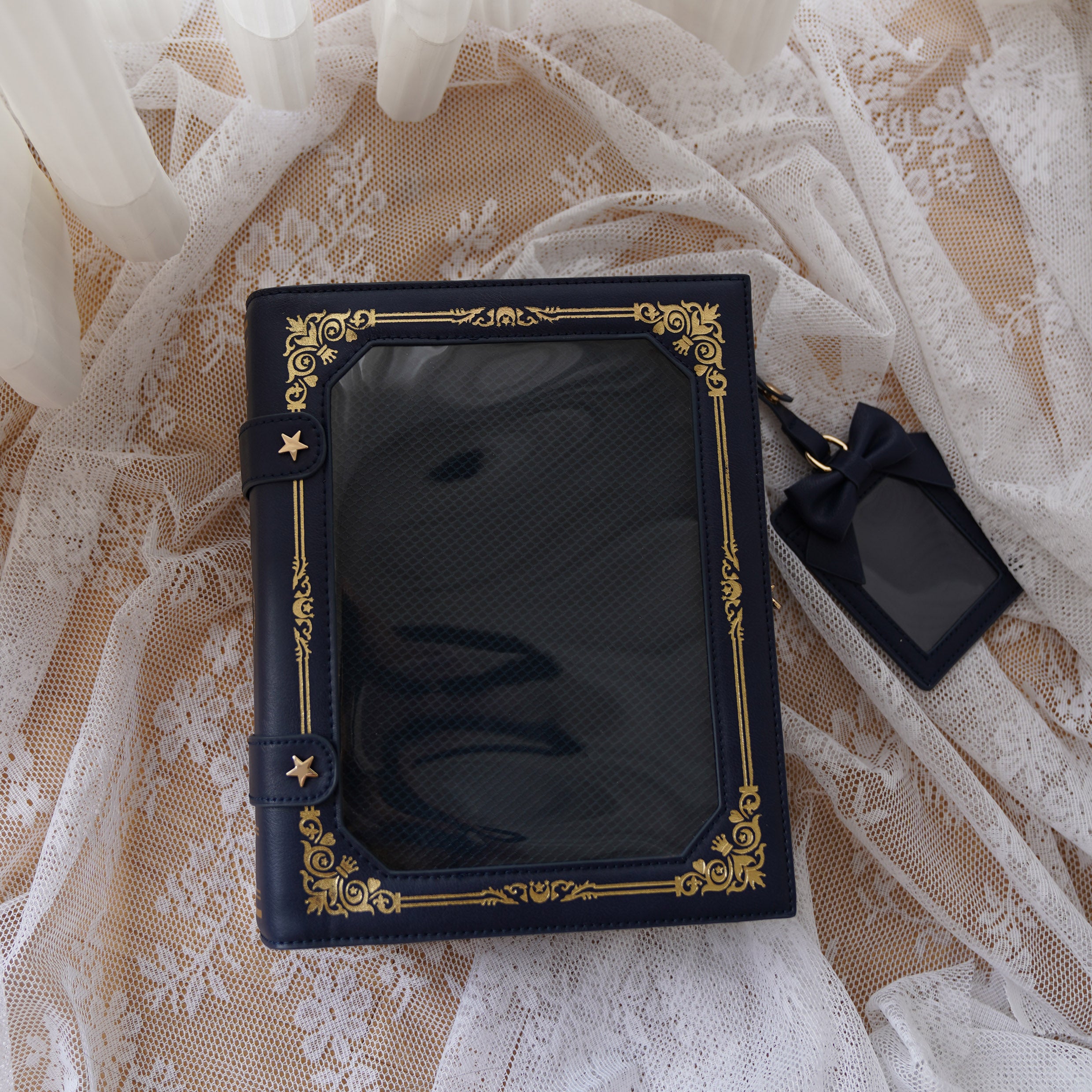 Navy blue vintage grimoire Jirai Kei ita crossbody bag with gold antique border star fasteners flat lay on lace