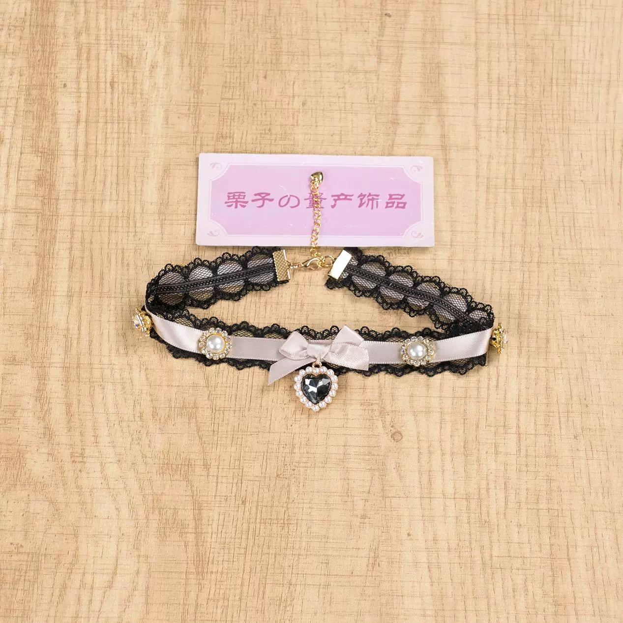 Black and pink Jirai Kei choker necklace with pink lace band black bow and heart rhinestone pendant front display