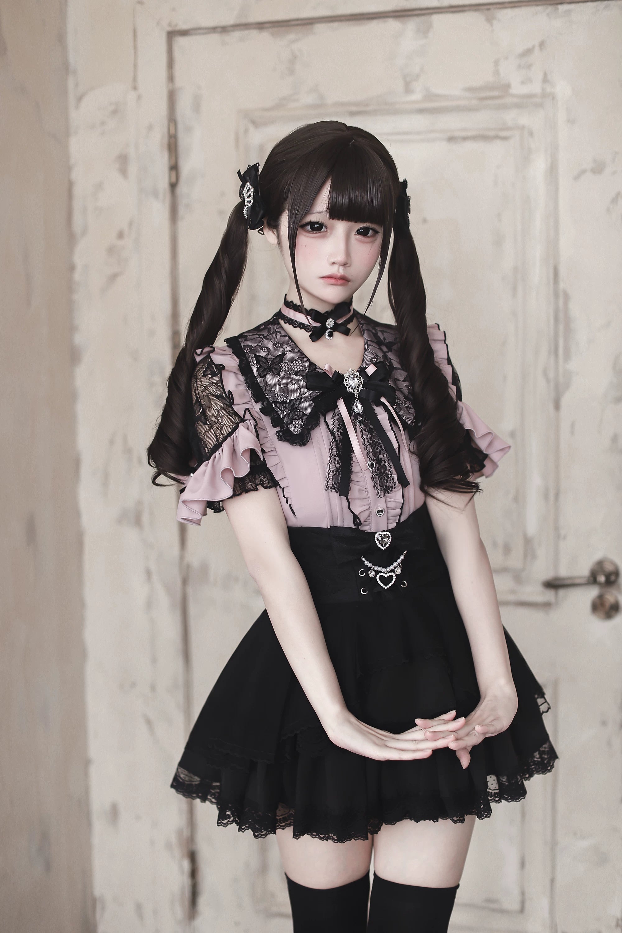 Pink and black Jirai Kei lace ruffle blouse with heart buttons worn with twin-tail hairstyle front full body view