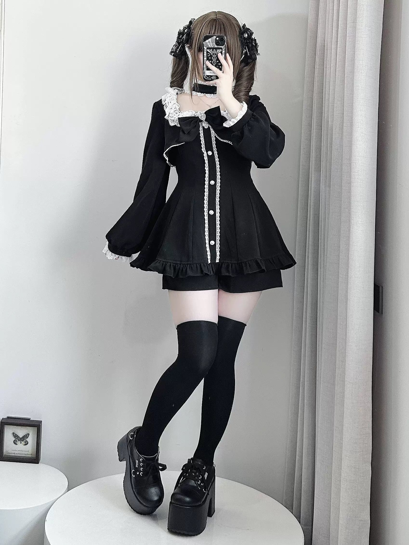Black Jirai Kei long-sleeve dress with off-shoulder ruffled collar, pocketed shorts, pearl trim details, black thigh-high socks and platform boots side selfie