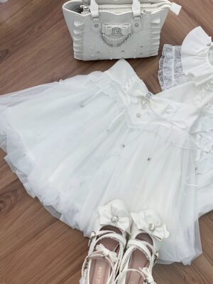 White Jirai Kei bubble skirt with lace detailing and rhinestone embellishments, styled flat lay with matching shoes and handbag on wooden surface