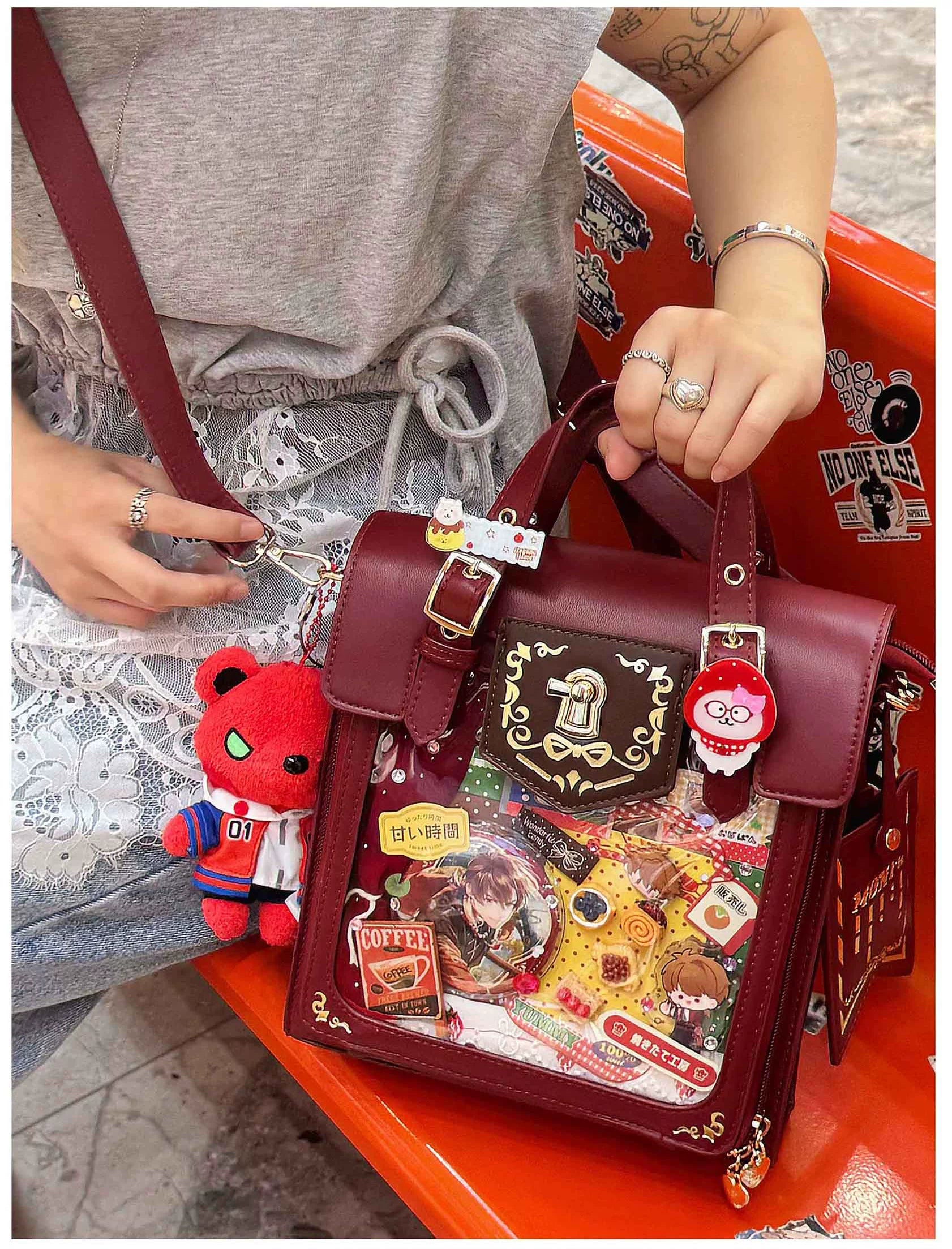 Burgundy vintage Jirai Kei ita satchel bag close-up showing embroidery quality, clear acrylic window craftsmanship, and luxury gold metal fixtures