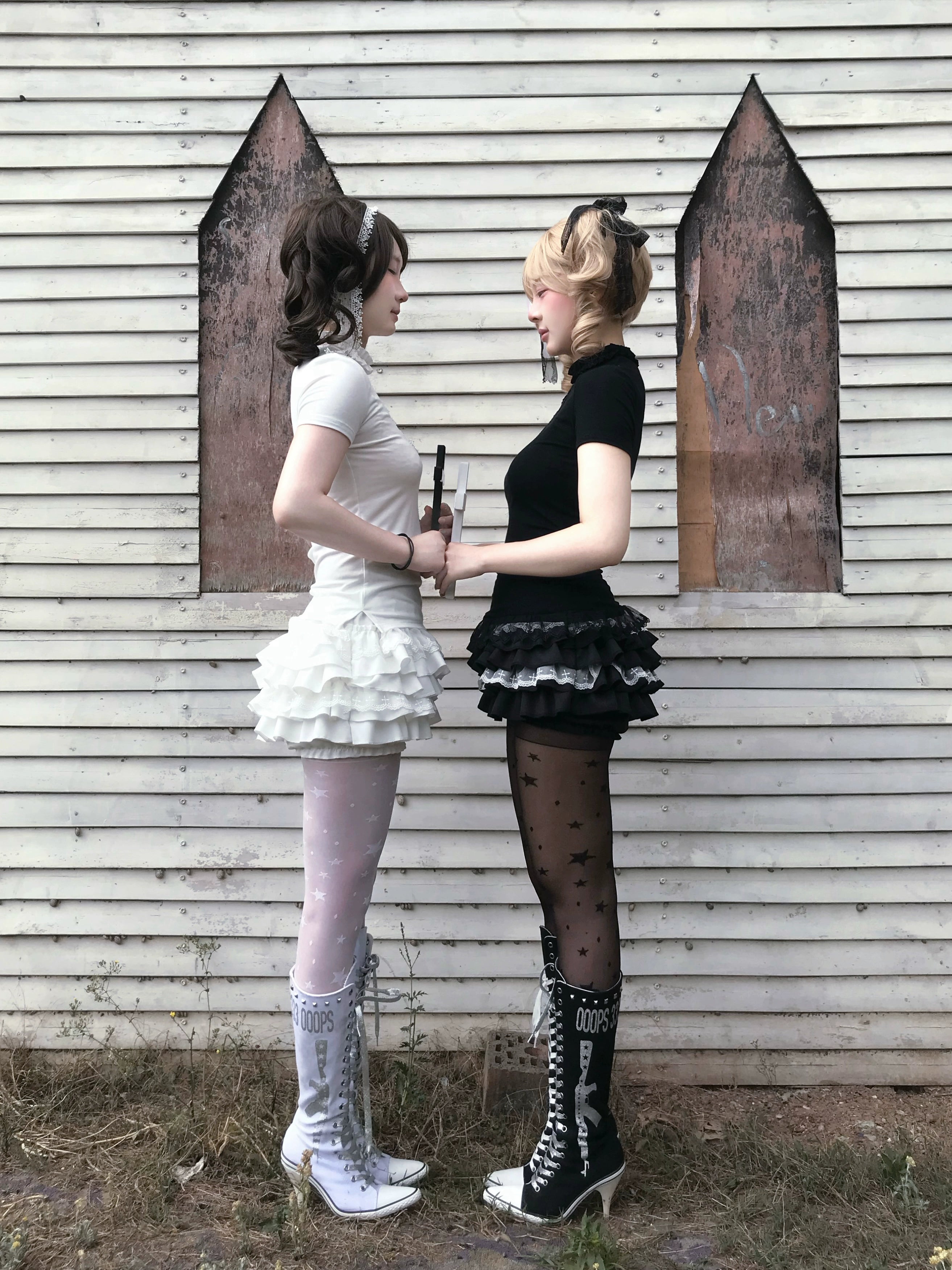 Detailed product shot of black gothic top with flocked cross embellishments and stretch fabric neckline