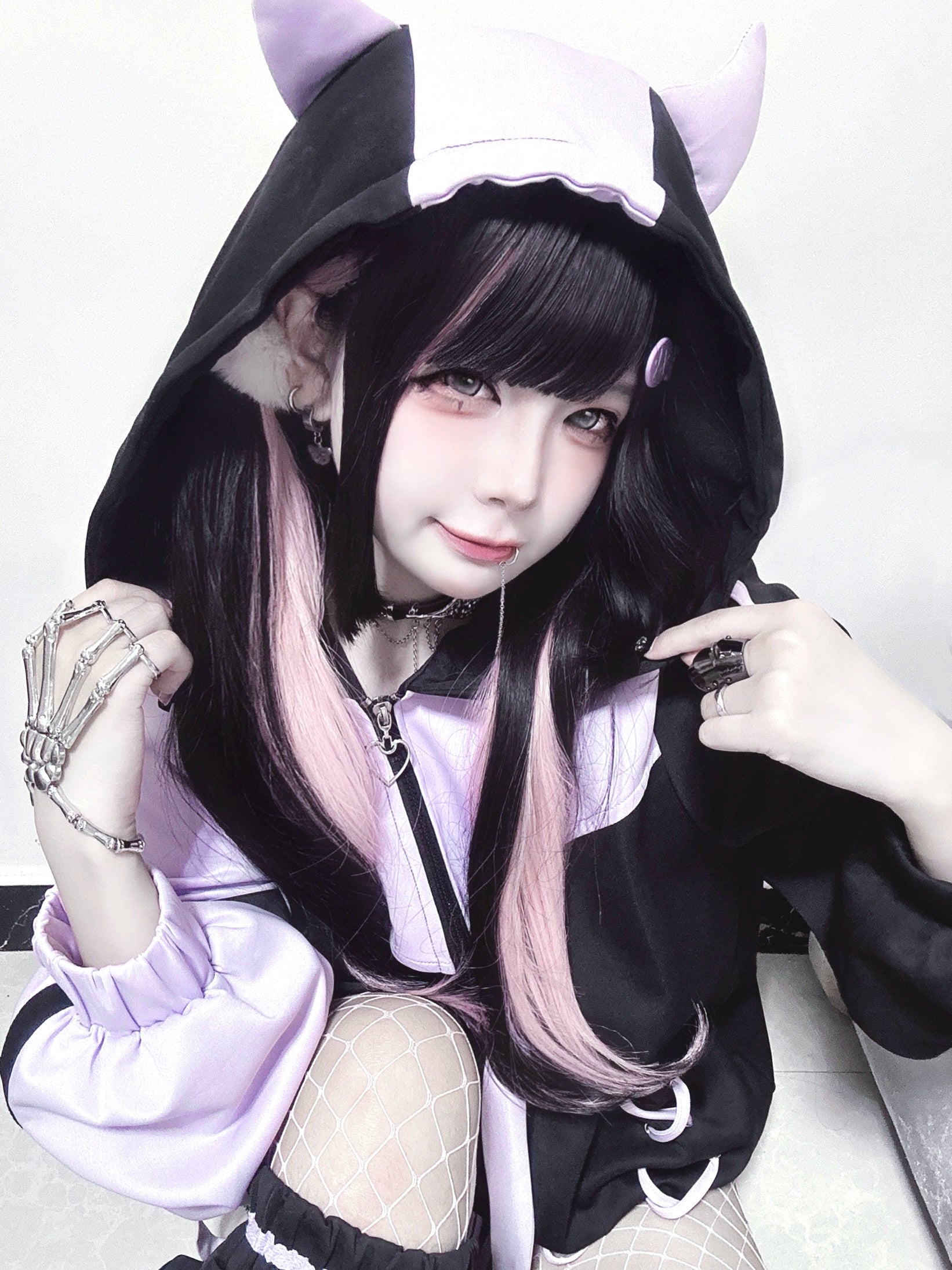 Black-purple Jirai Kei hooded lace-up jacket close-up showing oversized lantern sleeves and cross-lace chest detail on model with two-tone hair