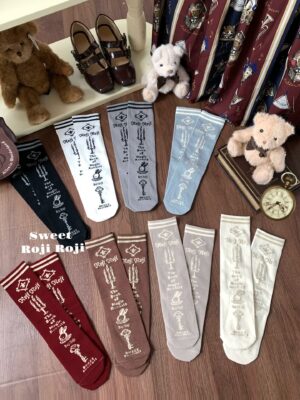 Multiple pairs of Jirai Kei vintage mid-calf socks in different colors with key candle bunny prints flat lay overhead view
