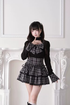 Black plaid Jirai Kei high-waist tiered ruffle skirt with corset lace-up details and delicate lace trim, front medium shot with long-sleeve top
