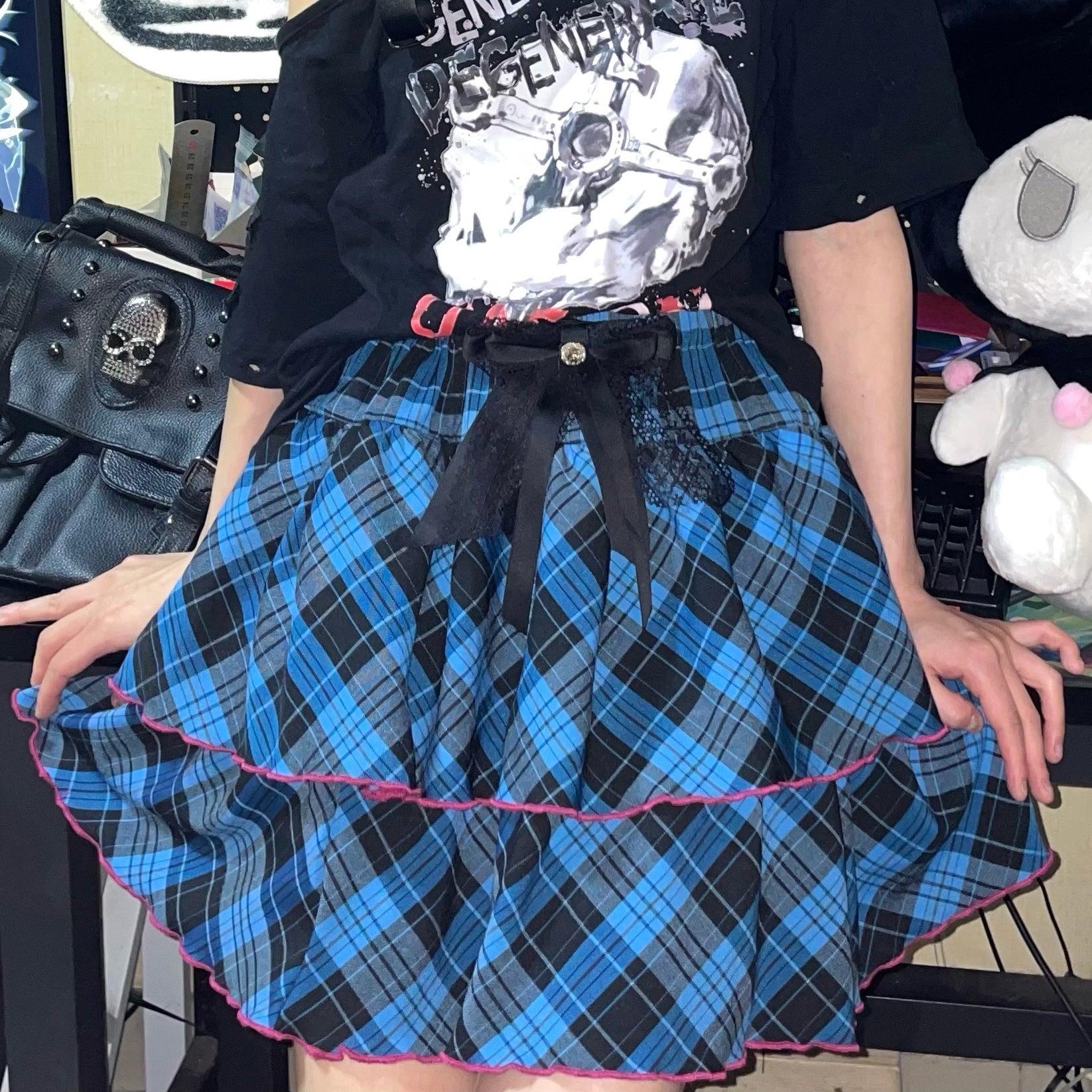 Blue-black plaid Jirai Kei ruffle skirt close-up front with large statement bow waist decoration and contrasting pink hem ruffle trim
