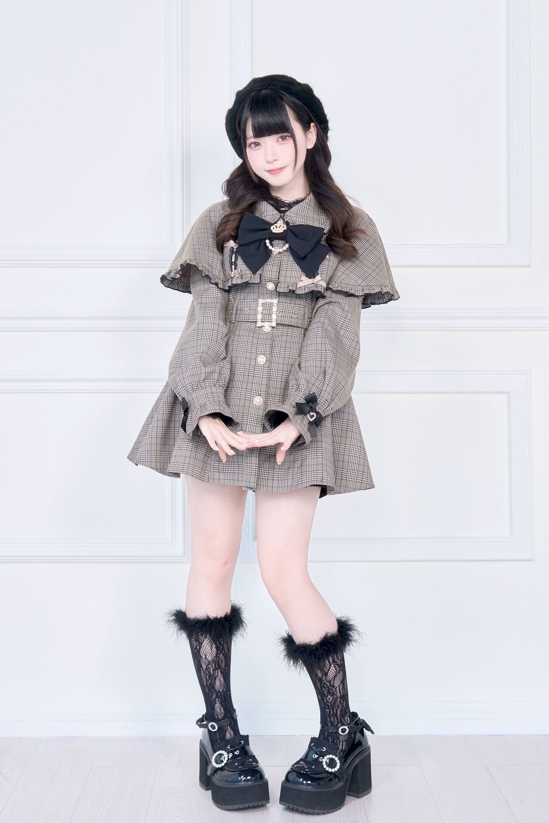 Jirai Kei cape trench coat front view with hands posed showing ruffled square metal waist buckle detail and cape trim