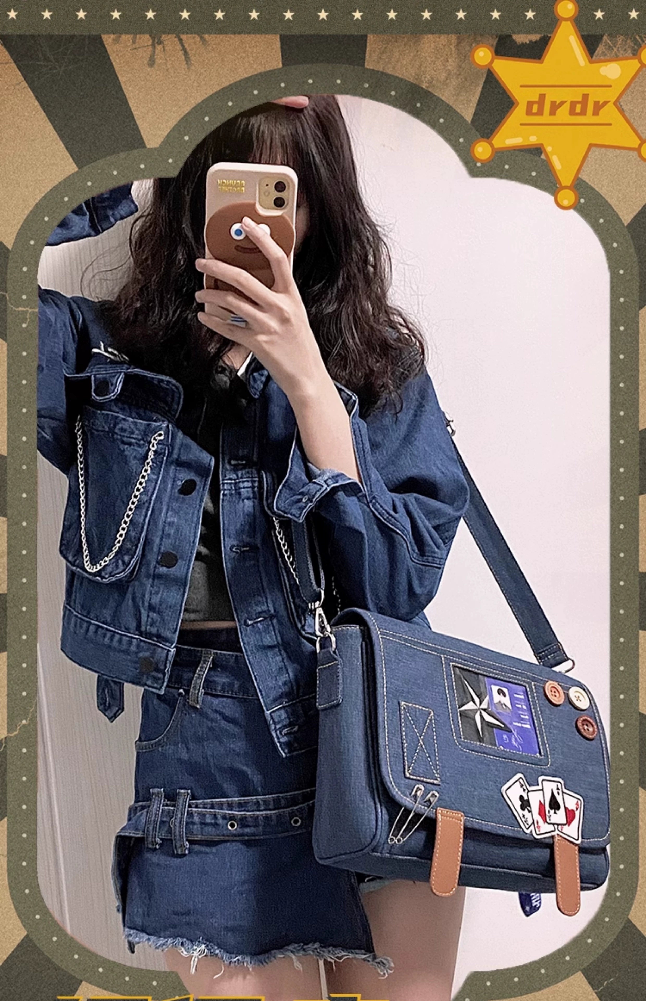 Denim itabag crossbody handbag front mirror selfie worn by model in denim jacket and mini skirt, decorative badges and playing card stickers with brown leather buckles