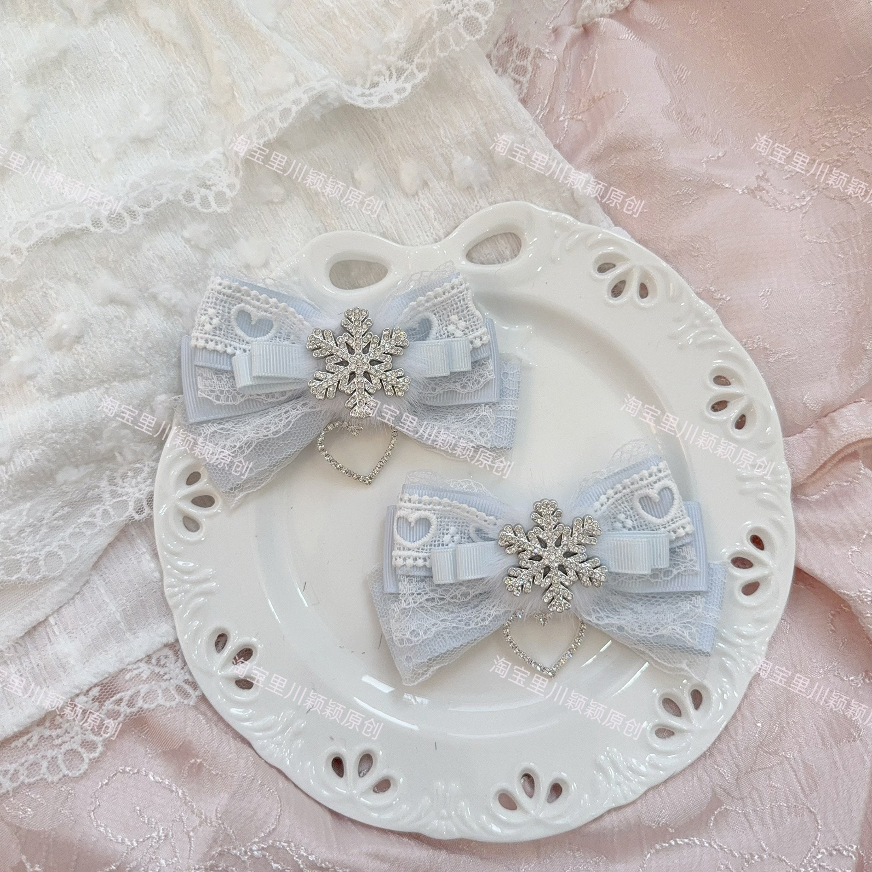 Light water blue Jirai Kei bow hair clips with silver snowflake decoration lace trim on white plate pink background ice fairy aesthetic