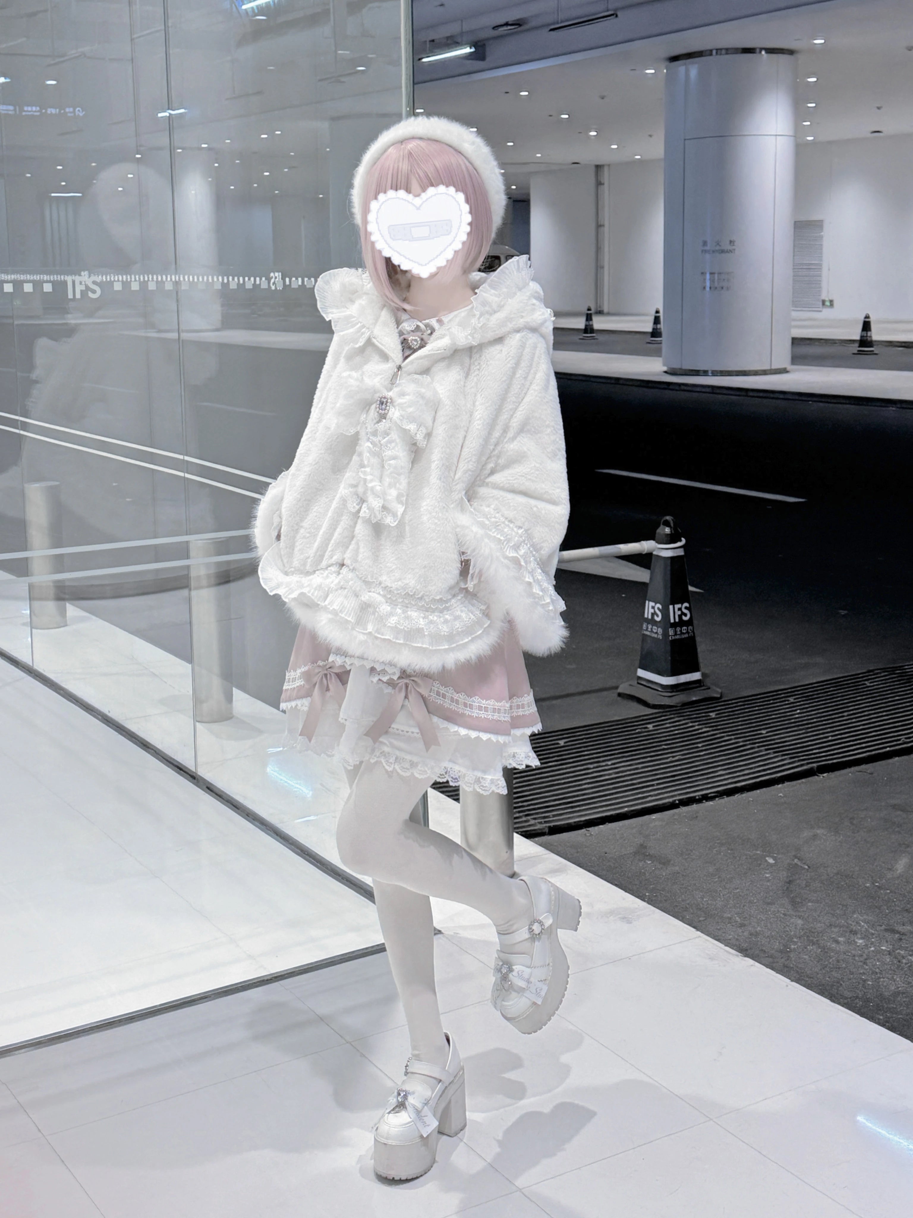 Styled flat lay of black jirai kei cat ear fleece cape coat with detachable pearl rhinestone bow tie accessory and styling components