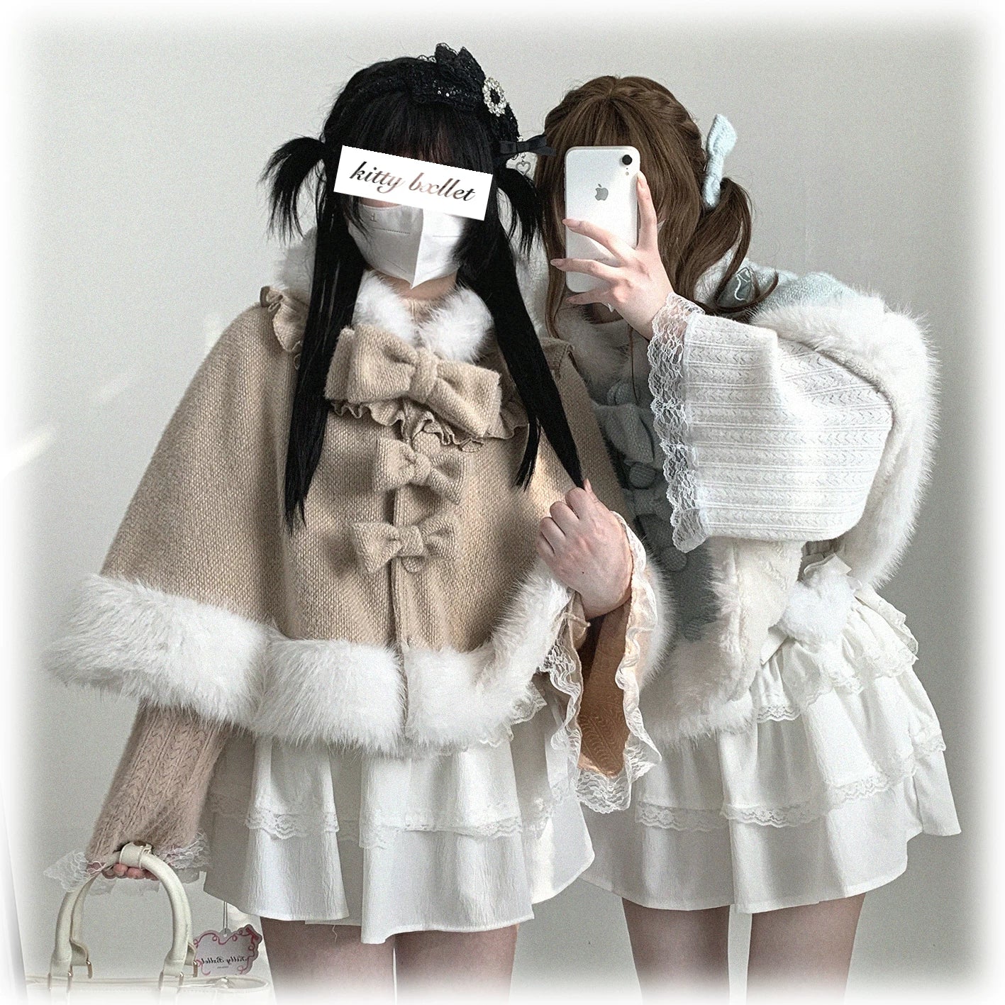 Close-up detail of cat-ear hooded cape showing light blue fabric, multiple decorative bows, front button fasteners, and white fuzzy trim