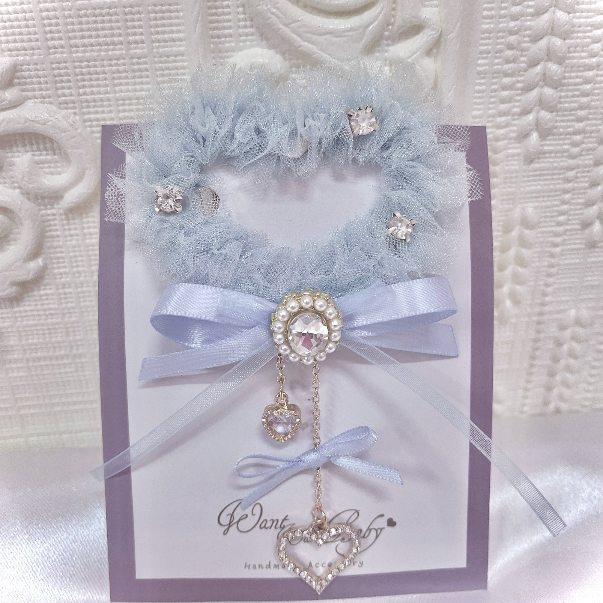 Light blue heart-shaped tulle hair clip with rhinestones and satin bow featuring hanging heart chain charm