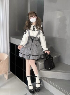 Three-quarter view of jirai kei outfit displaying corset-style waist design criss-cross overall straps lace ruffles and bow accents with black handbag styling